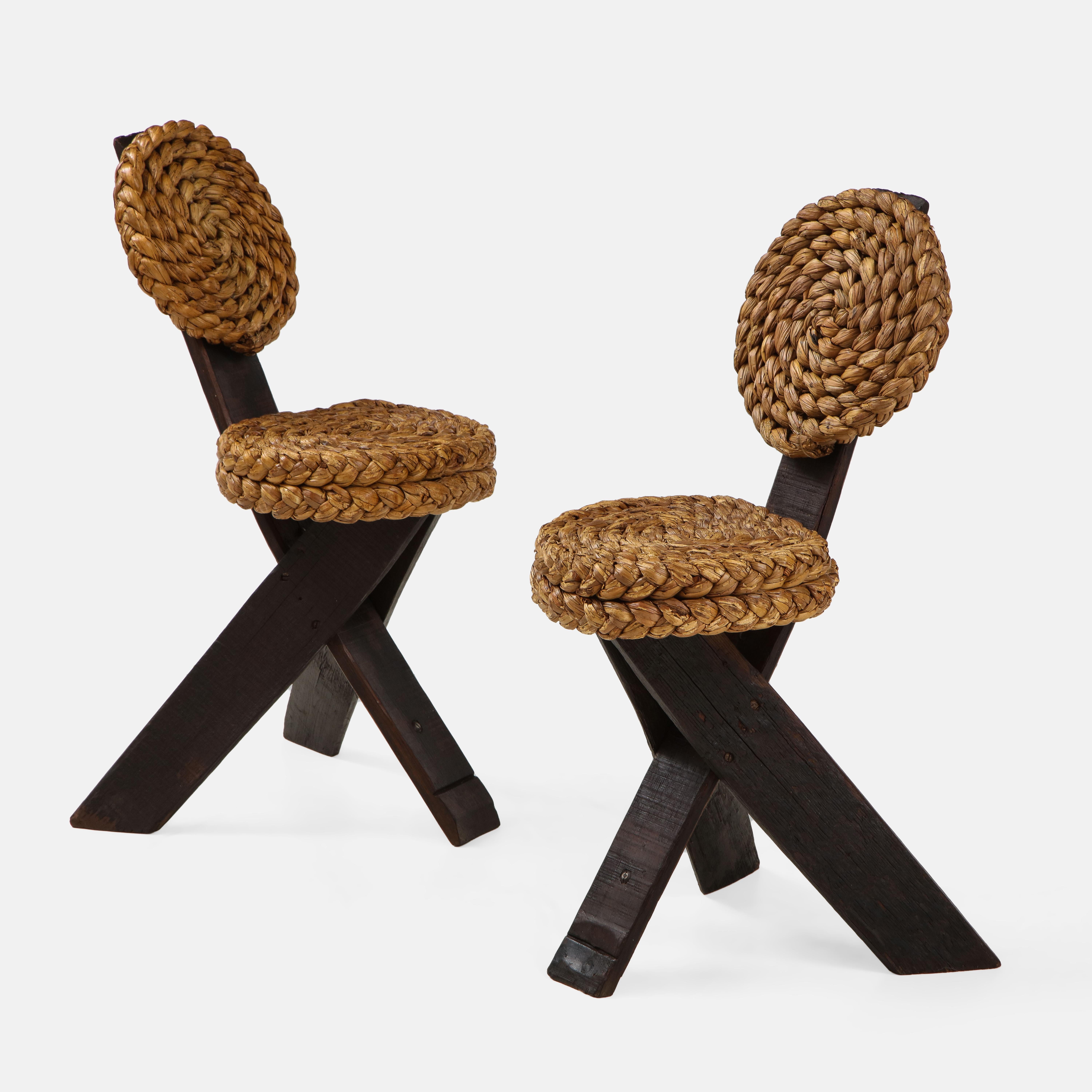 Adrien Audoux and Frida Minet rare pair of brutalist side chairs with braided rope backs and seats on stained wood frames ending in tripod legs. These unusual sculptural chairs are a typical Audoux et Minet modernist design incorporating elements of