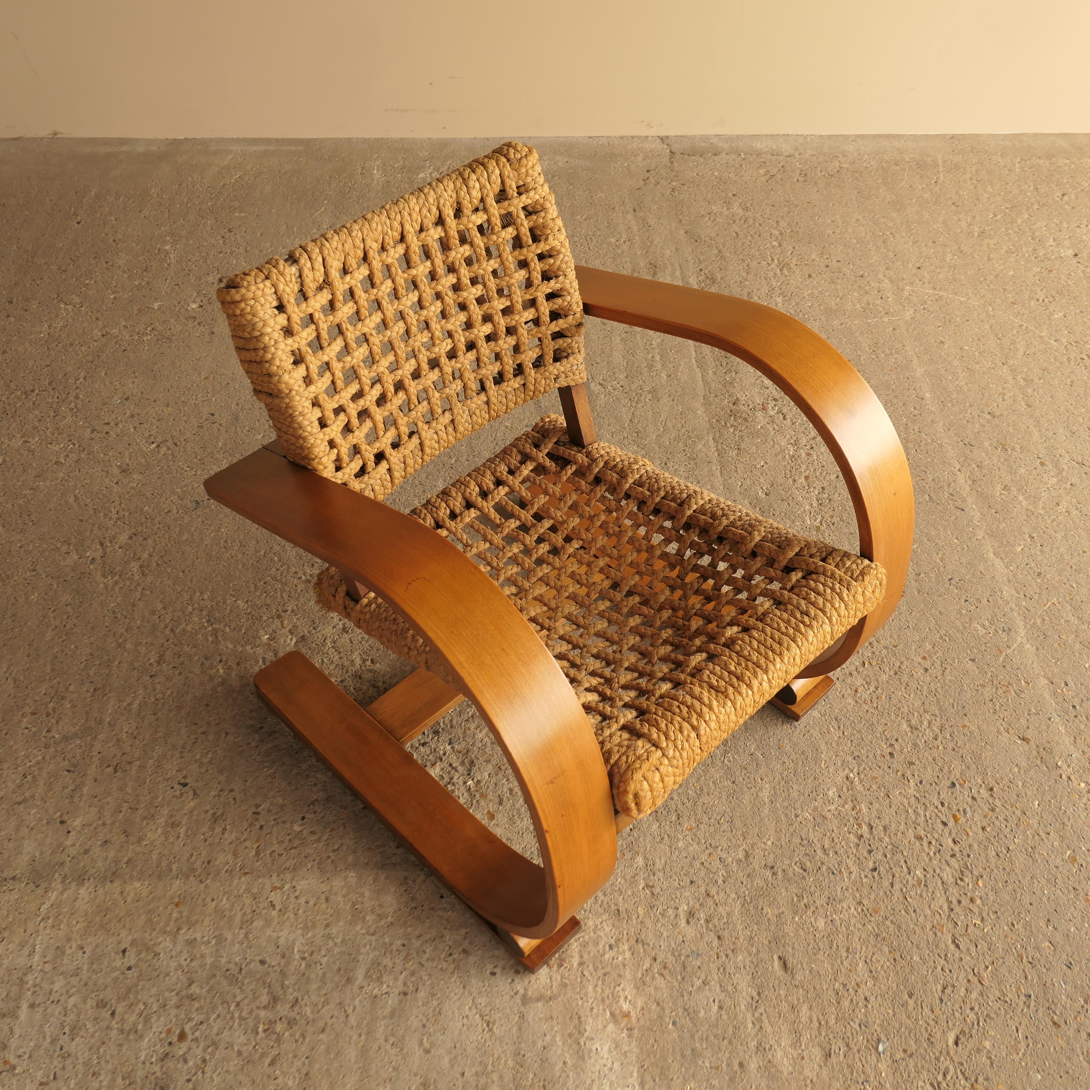 Exceptionnel fauteuil luge conçu par Audoux & Minet pour Vibo Vesoul, France, dans les années 1940. Cette pièce élégante présente un cadre en chêne blond courbé à la vapeur avec une assise et un dossier en corde tressée à la main, signature des