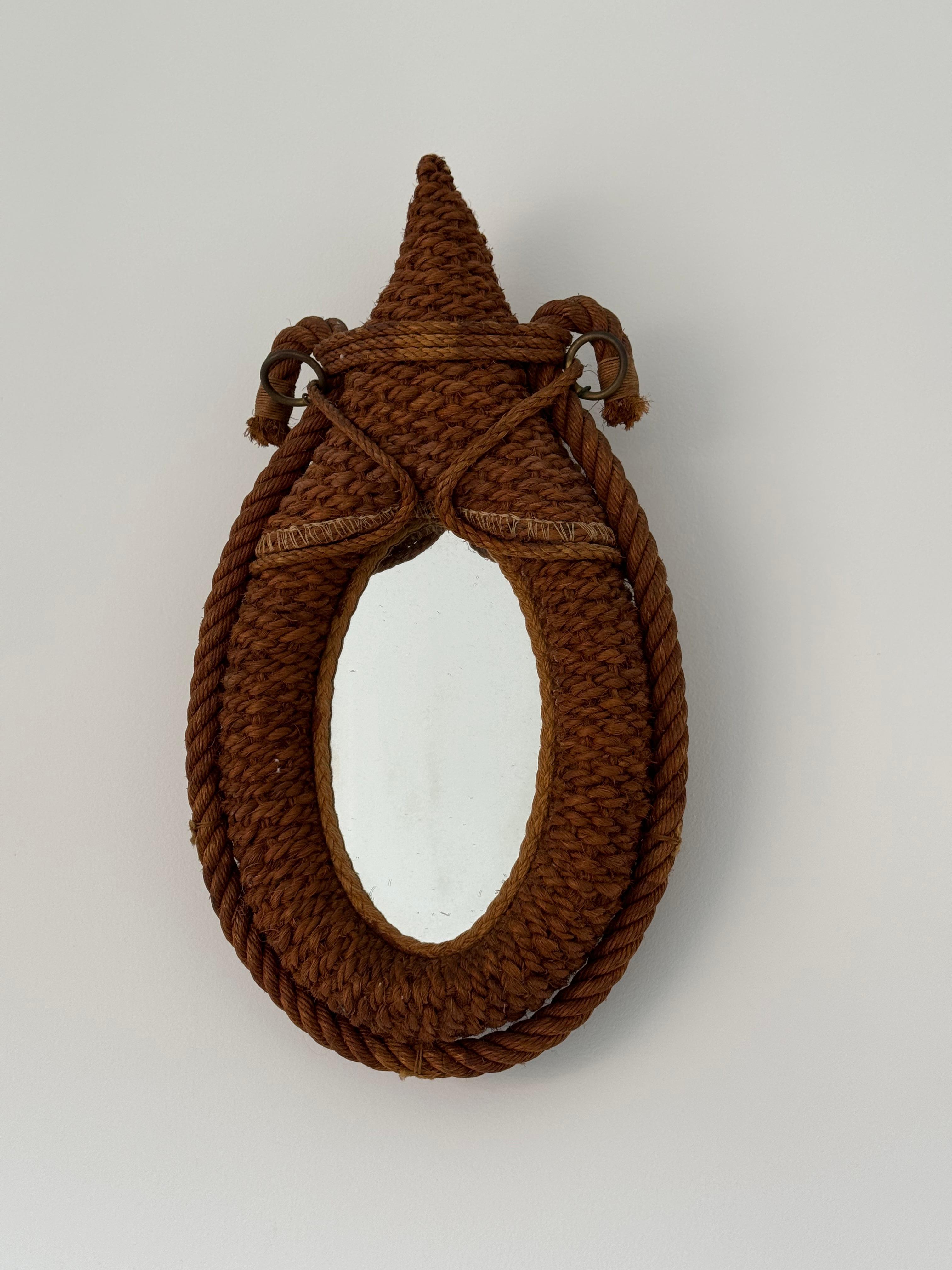 Design rope wall mirror attributed to Adrien Audoux & Frida Minet.

Mirror shaped like a horse collar.

Original oval shaped mirror has light fogging  Mirror frame comprised of signature braided rope.

Good condition.

france 1950s