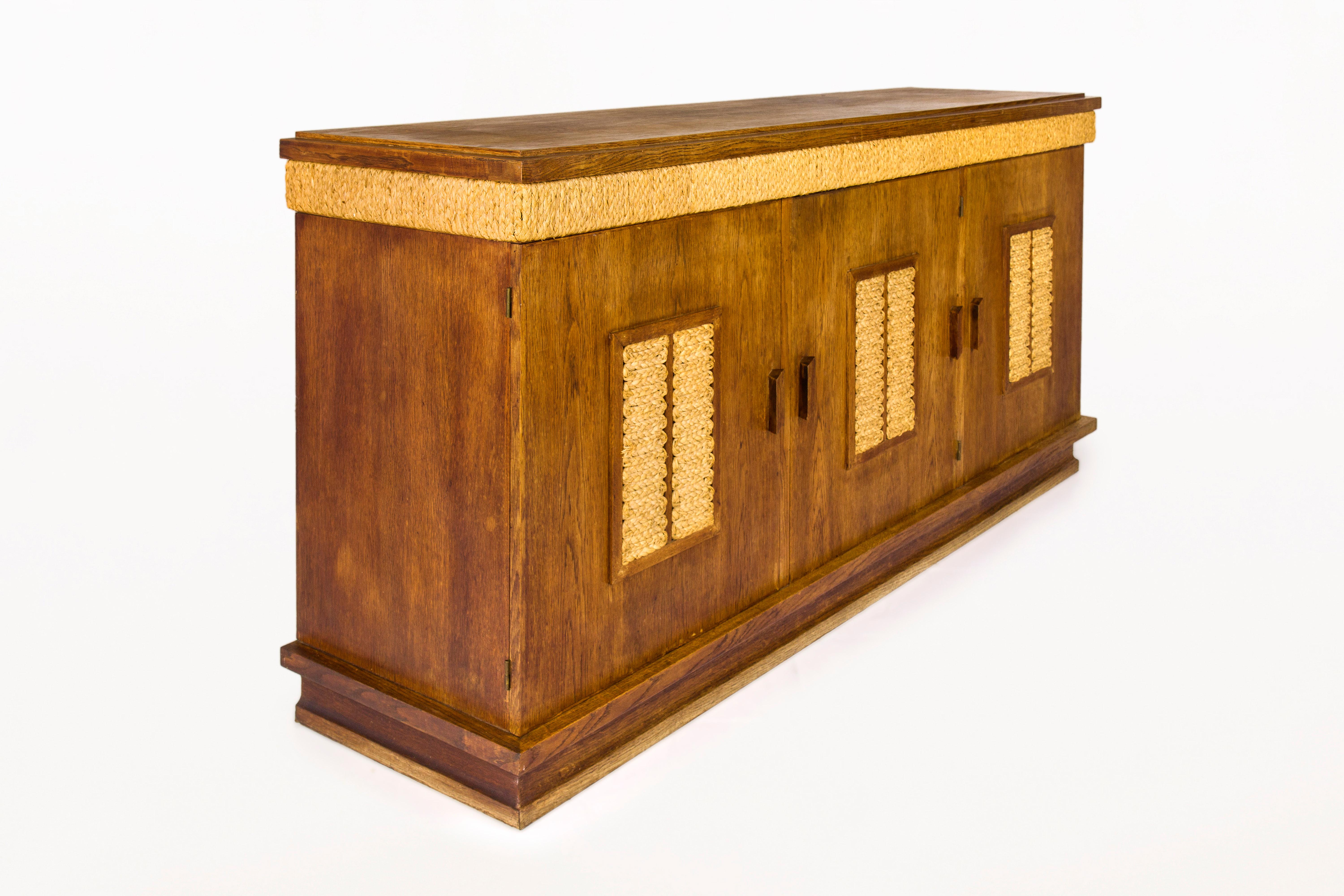 Adrien Audoux & Frida Minet sideboard.
Rope detailing.
Oak top.
3 door sideboard, with central interior drawers
circa 1950, France.
Very good vintage vondition.
Adrien Audoux and Frida Minet were a French couple and worked as designer.
During