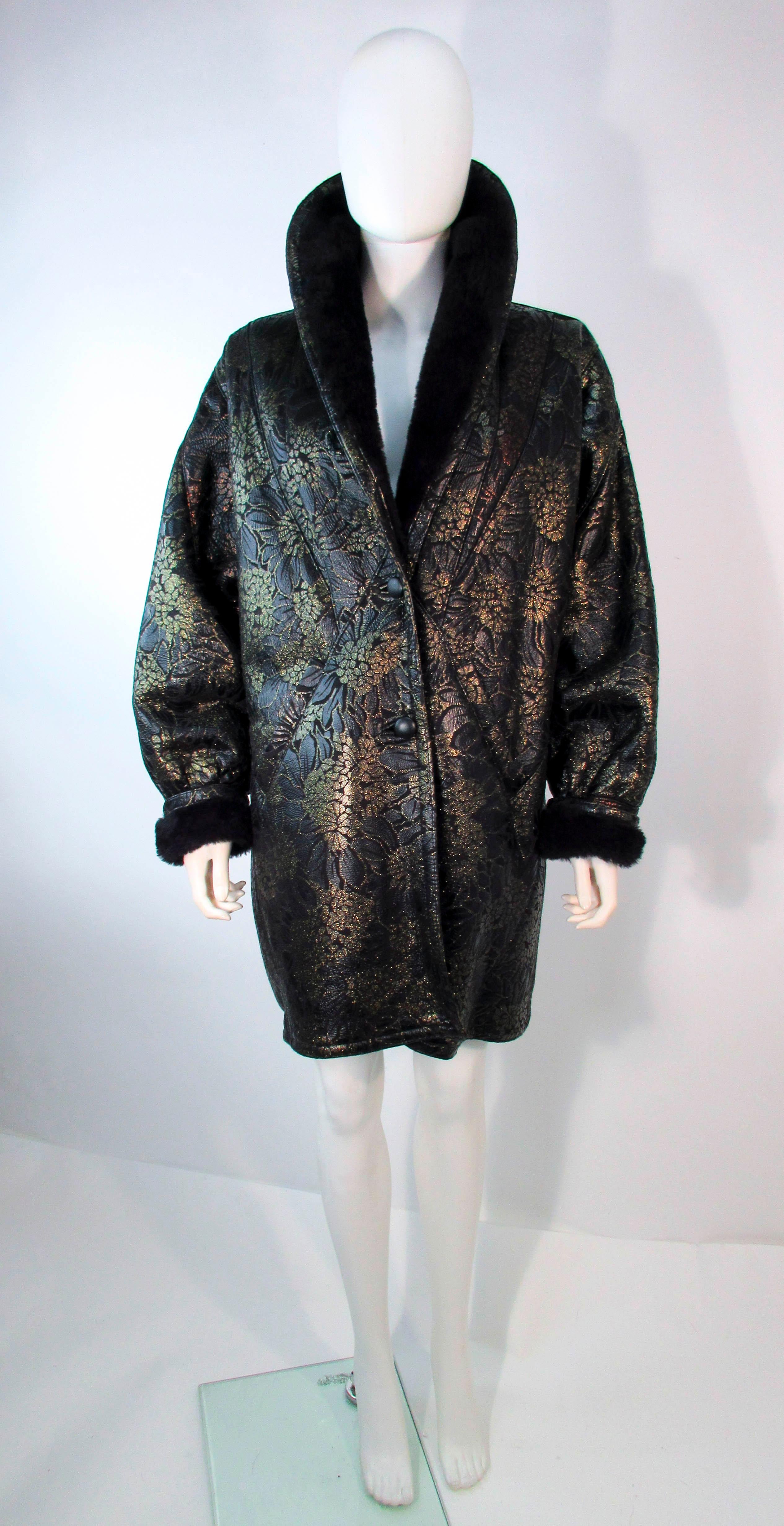 This is a stunning design by Adrienne Landau. The coat is composed of a black patterned leather with a metallic multi-color floral shearling coat. There are two pockets and the sleeves can be cuffed. There are center front button closures. In