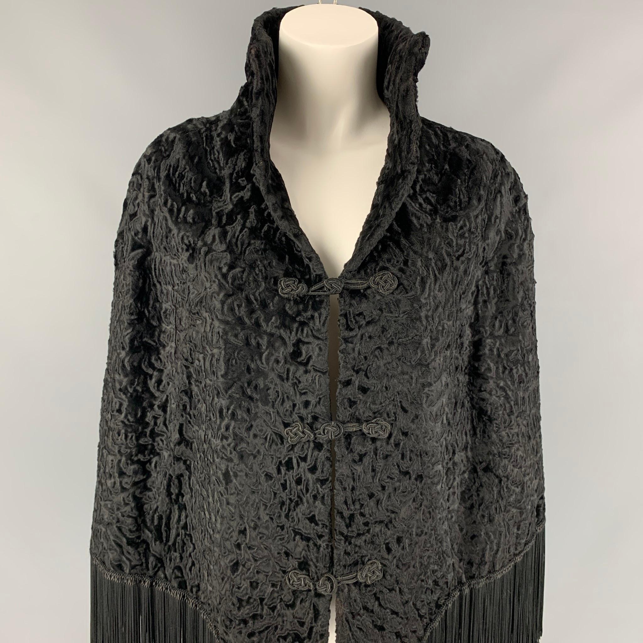 ADRIENNE LANDAU x WACHTENHEIM cape comes in a black textured ashtrackhan fur featuring a shawl collar, fringe trim, and toggle button closure. 

Very Good Pre-Owned Condition.
Marked: Size tag removed.

Measurements:

Shoulder: 18 in.
Length: 27 in. 