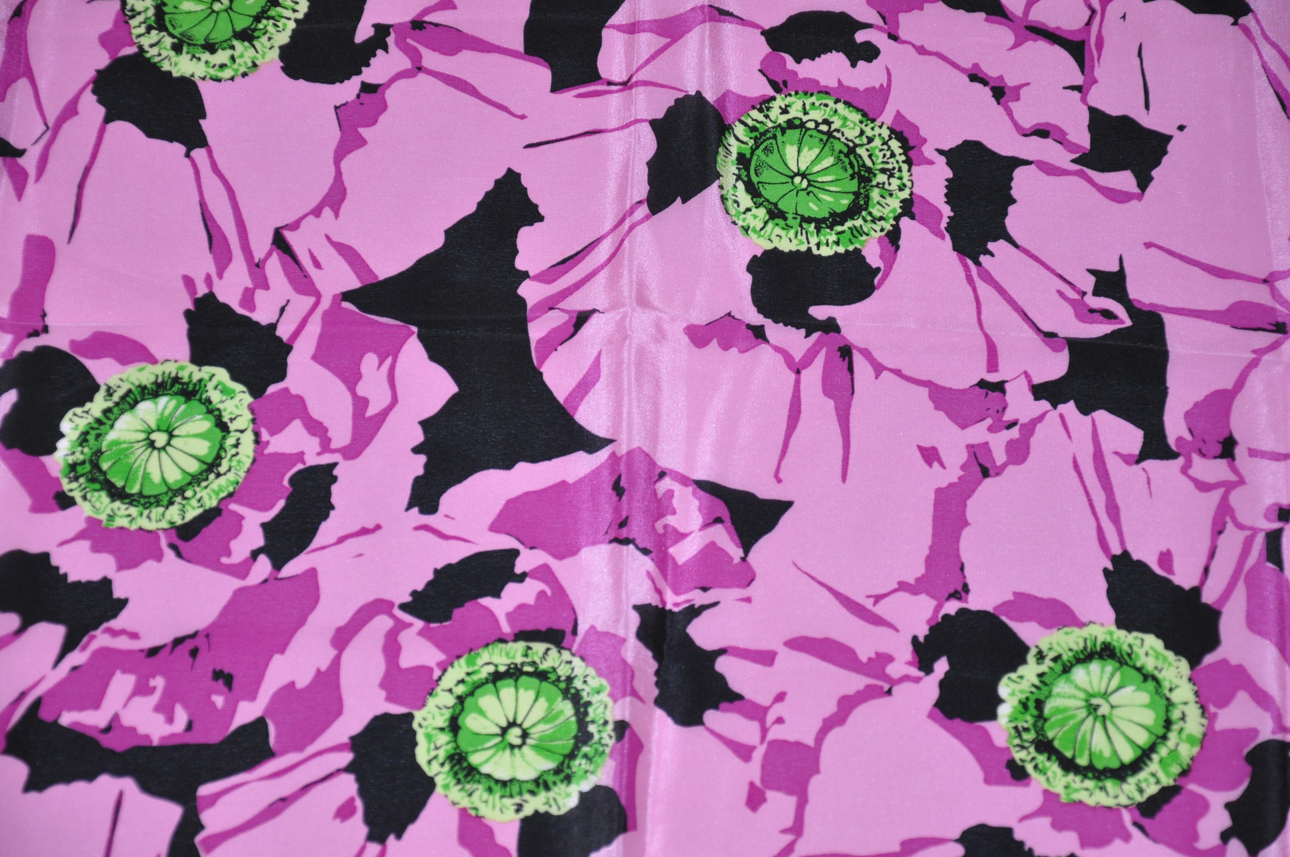      Le foulard en soie Adrienne Vittadini, merveilleusement élégant, présente des bordures florales noires et blanches entourant d'audacieuses nuances de fleurs violettes. Il mesure 30 pouces sur 31 pouces. Bords roulés à la main et fabriqués au