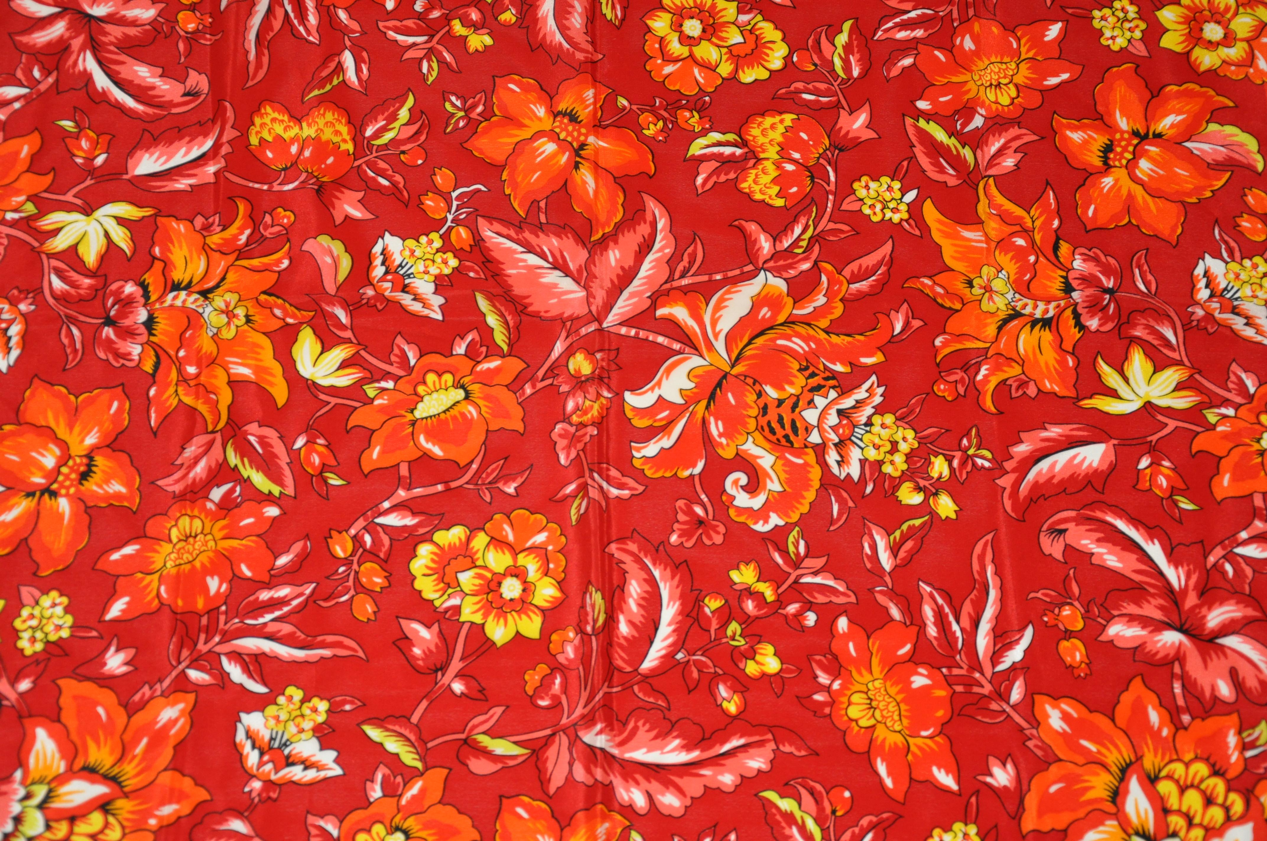      Adrienne Vittadini wonderfully glorious floral silk scarf in bold shades of reds and tangerine measures 31 inches by 30 inches. Rolled edges and made in Italy.