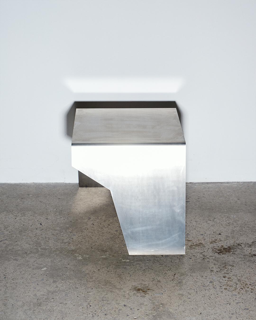 Beistelltisch aus Aluminium.  Kann mit dem Schnitt auf der linken oder rechten Seite bestellt werden.