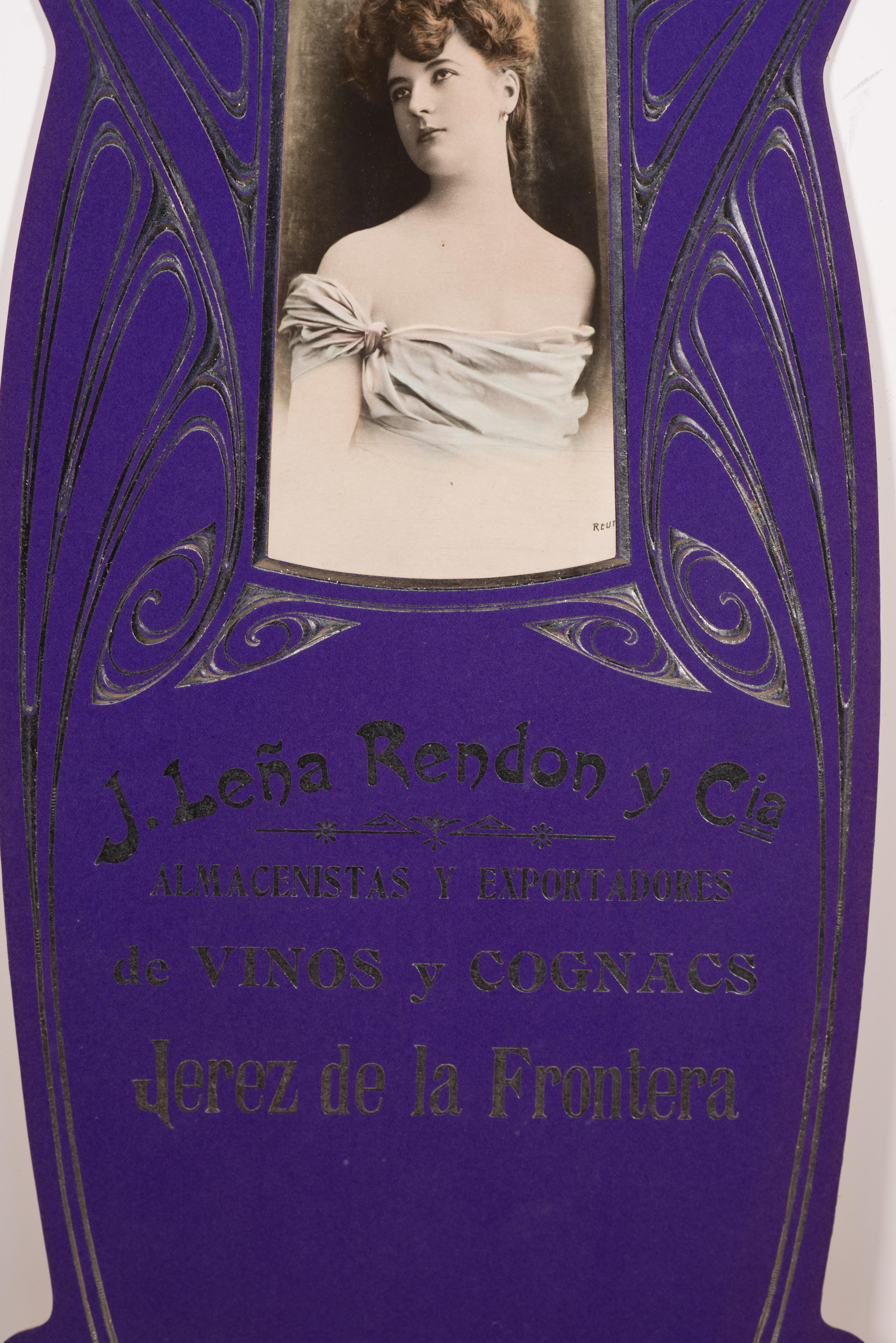 Werbeplakat, J. Leña Rendon und Co., Wein- und Cognac-Lagerhäuser und Exporteure, Jerez de la Frontera. Pappe. Erste Hälfte des 20. Jahrhunderts. 
Interessanterweise erscheint das Foto der Dame auch auf einer Postkarte (Serie 35, Nr. 8) des