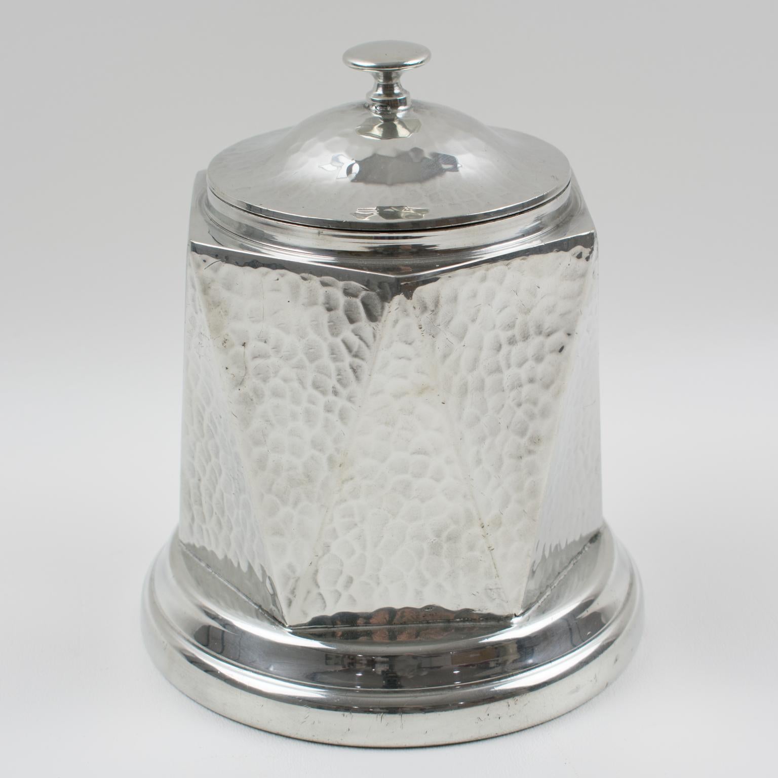 This stunning English Art Deco geometric hand-hammered dinanderie, polished pewter-covered decorative box or tea caddy, was manufactured by A.E. Poston & Company, Birmingham, England, for their Knighthood Old English Pewter Collection. The beautiful