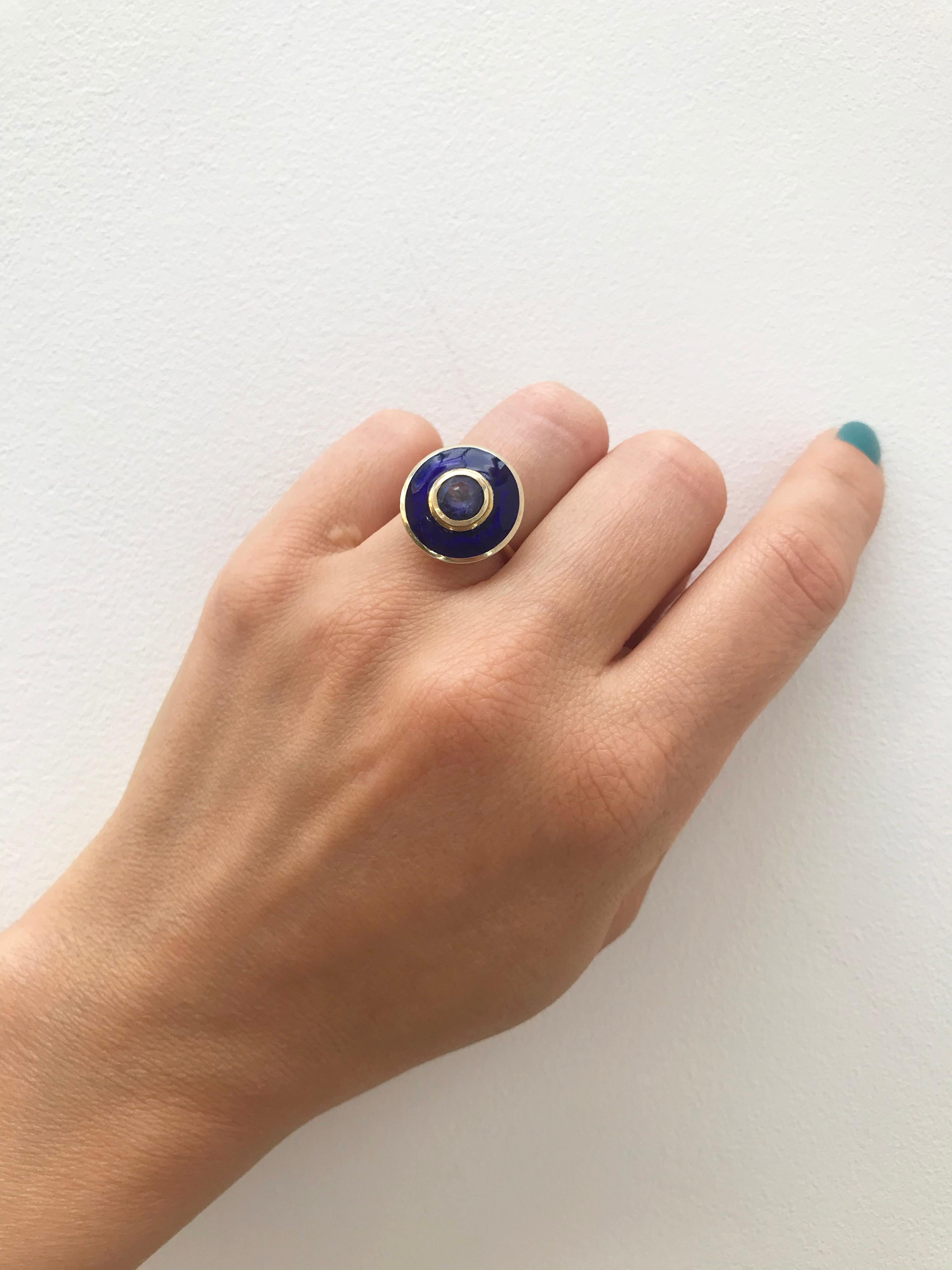 Rooted in clean, classic lines, this a bold yet elegant cocktail ring reflects the individuality of the wearer. This Art Deco inspired ring using the venerable vitreous hot enamel which compliments the hand as the iolite picks up the light. 