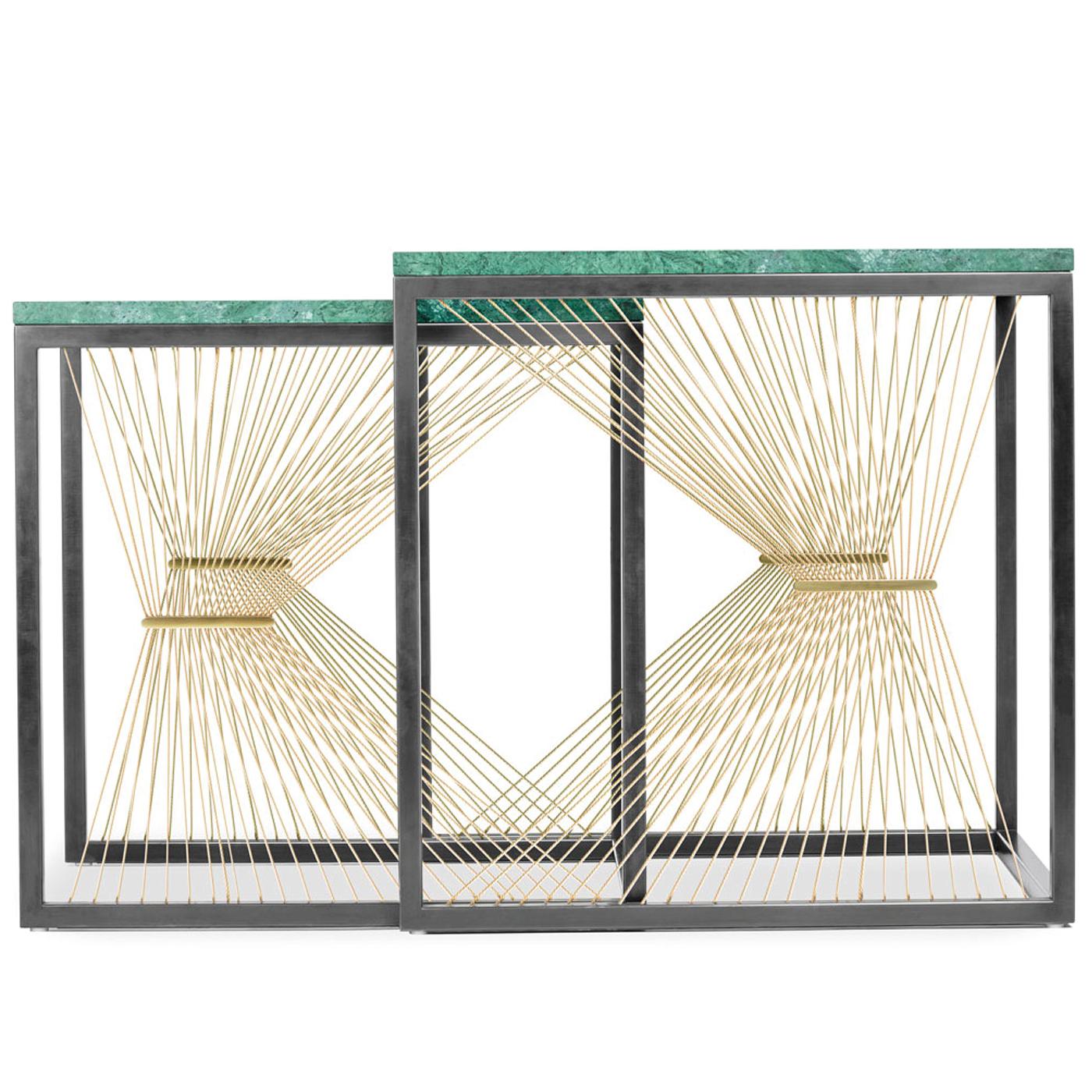 The elegant simplicity of this contemporary set of two nesting tables disguises a complex construction. An open blackened steel structure supports the green Guatemala marble tops, while on the sides gilded steel wires are held by polished brass