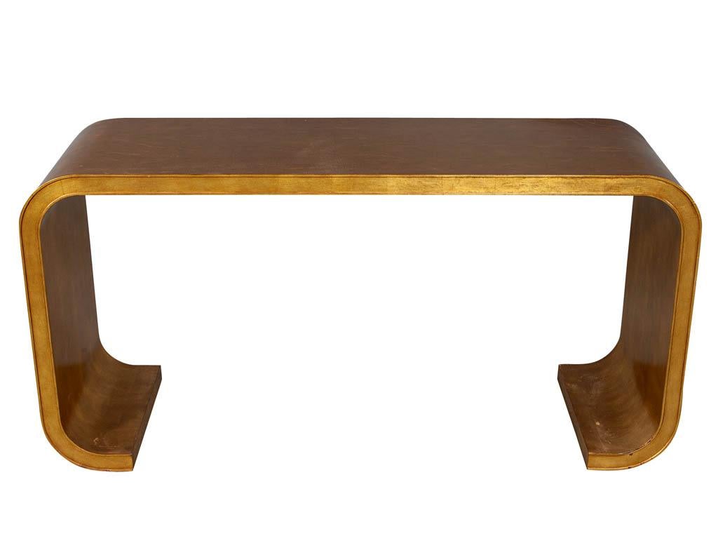 Aerin Lauder modern edgewood gold leaf console table. All original with some scratches on top and legs - photos included.

Price includes complimentary curb side delivery to the continental USA.