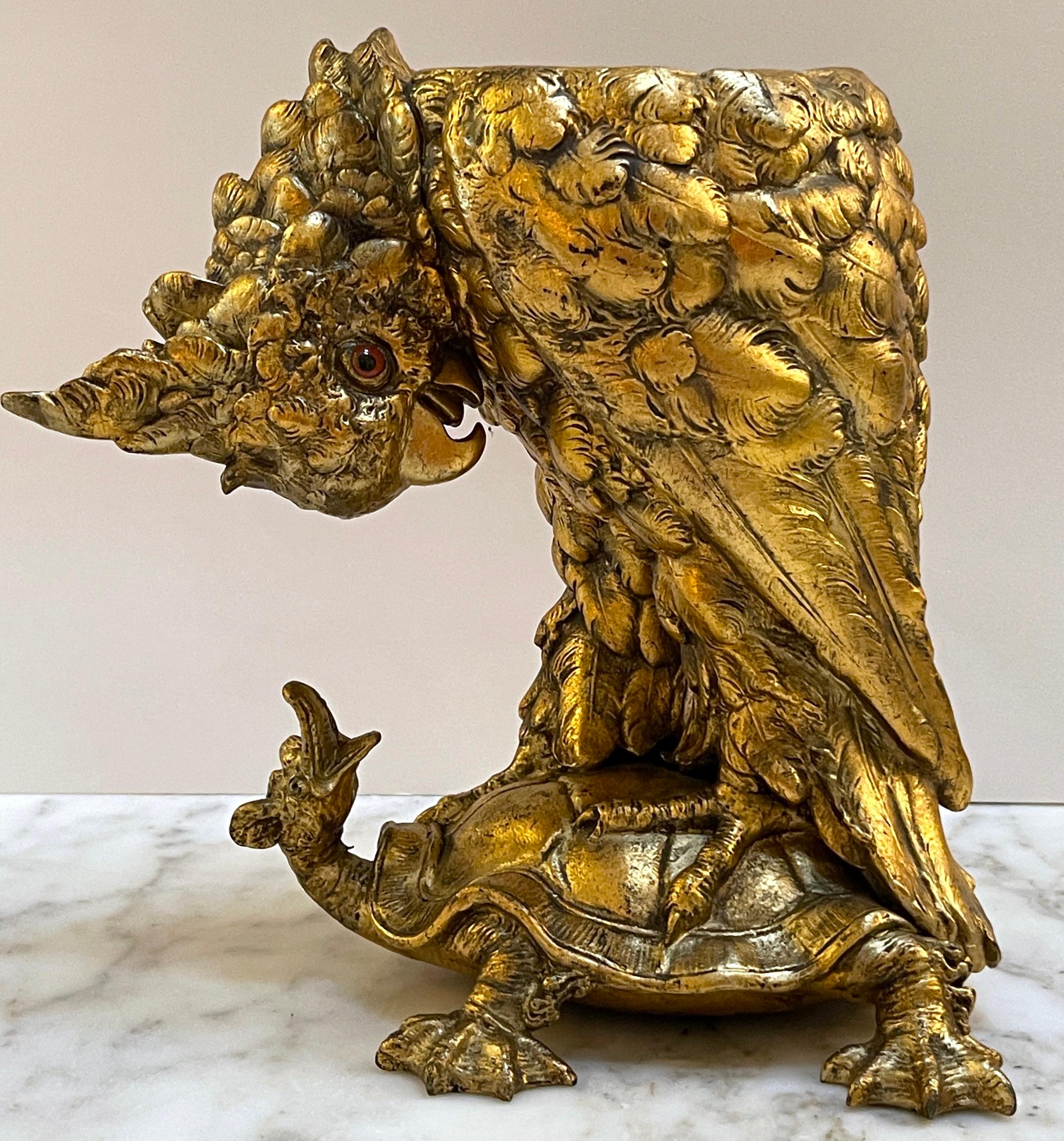 Aesthetic Gilt Metal Cockatoo & Turtle Figural Cachepot 
USa, circa 1900s

Of large Size and scale, realistically cast and modeled of Cockatoo with inset glass eye, standing on a turtle. 

Overall measurements 12-Inches high x 12-Inches wide x