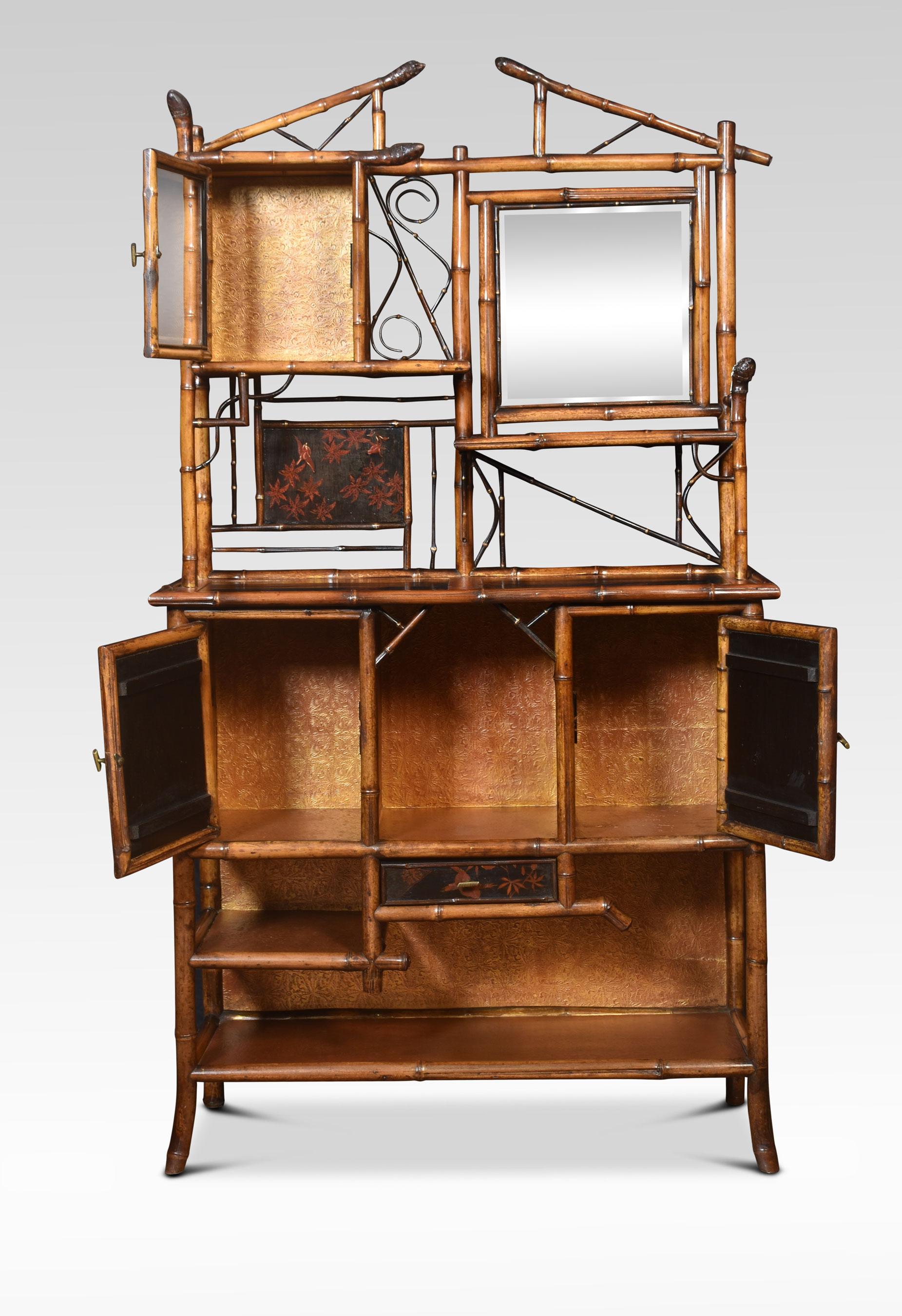 Aesthetic movement bamboo and lacquer cabinet having an openwork architectural pediment above a beveled glass door flanked by a mirror plate. To the lower section with rectangular top and lacquered panels over a pair of frieze bone inlaid paneled