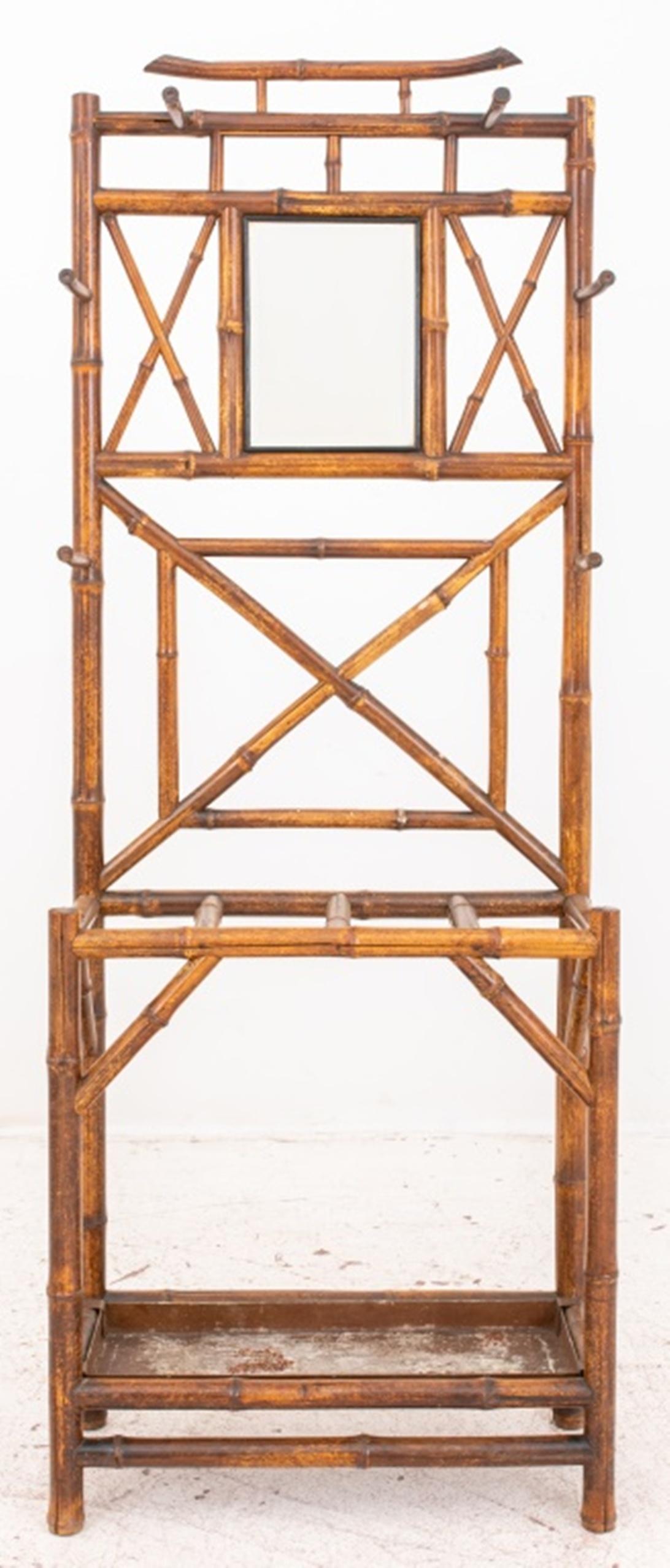 Aesthetic Movement hall tree, having a patterned bamboo frame, beveled mirror, four coat hooks and four compartment walking stick / cane / umbrella rack with pan, circa 1900s. 
Dimensions: 72.5