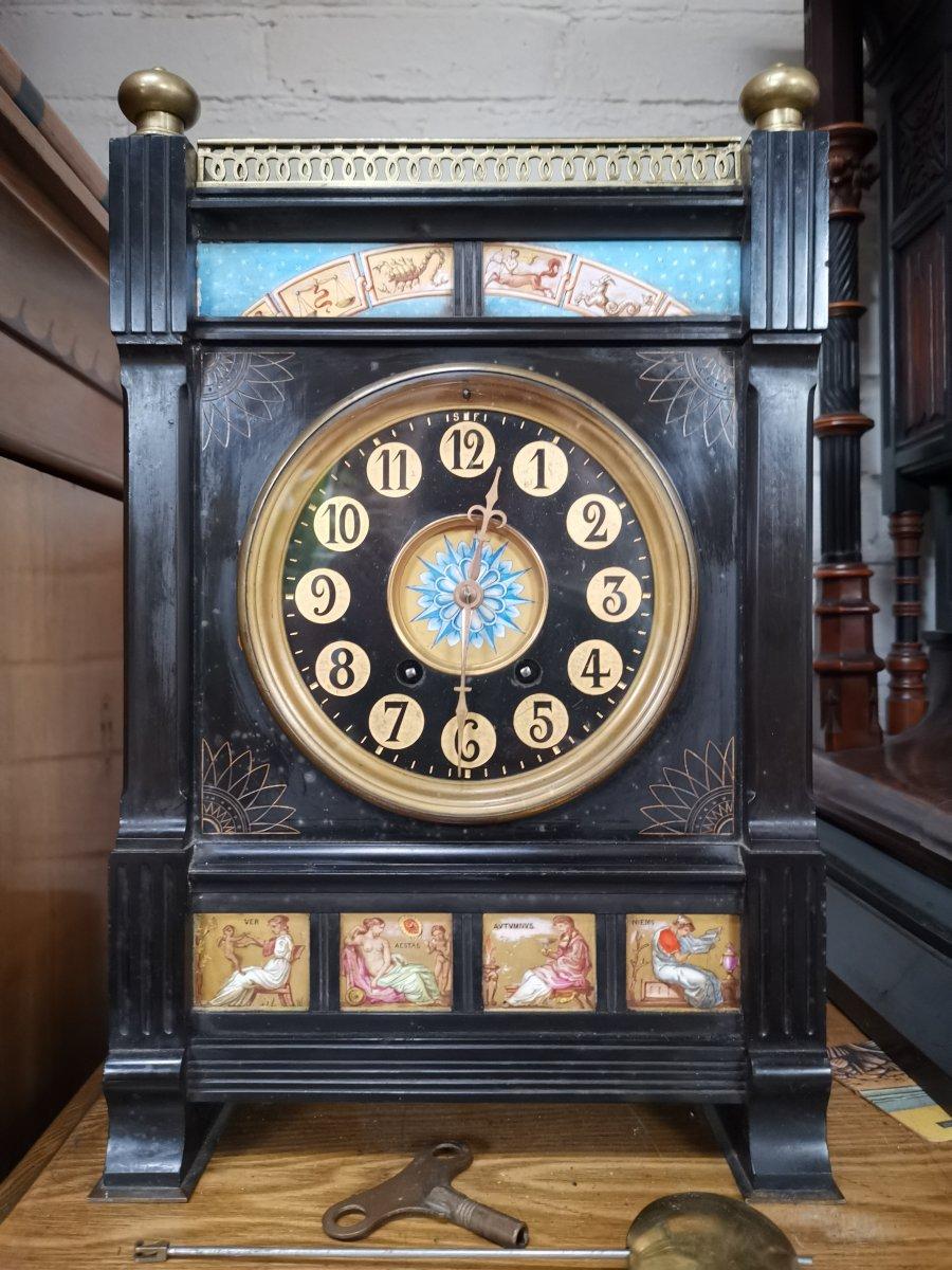 A rare and wonderful Aesthetic Movement black marble brass gong-striking mantel clock with brass finials and brass gallery to the top, just below with hand-painted porcelain panels of the signs of the Zodiac and an Arabic numeral 6.5 inch dial with