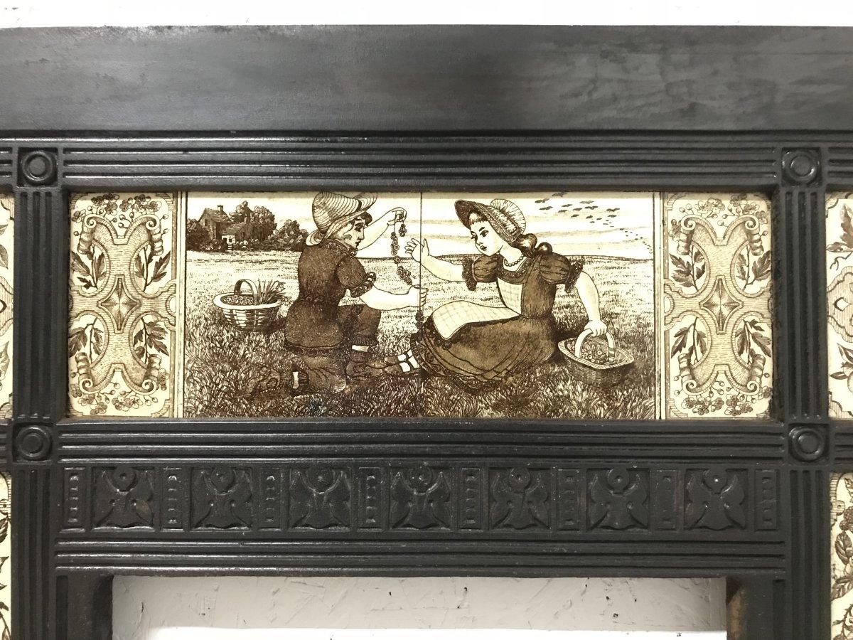 English Aesthetic Movement cast iron fire insert in the style of Thomas Jeckyll with the original aesthetic movement tiles depicting children picking flowers and making daisy chains to the top with two boys to the left taking birds eggs and two