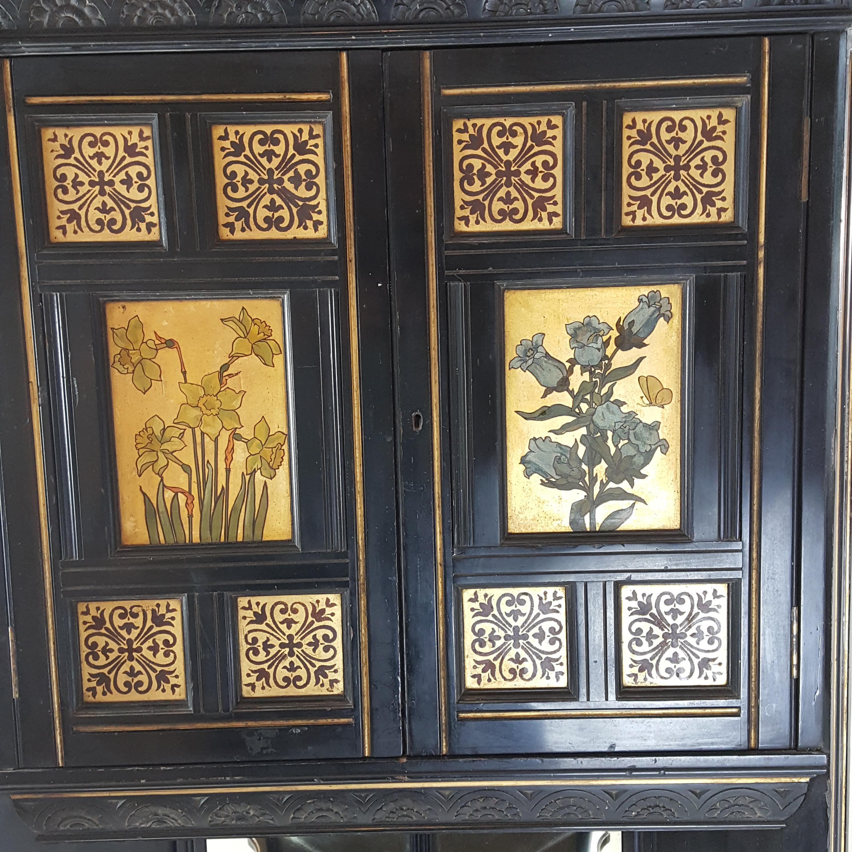 Fine quality English Aesthetic Movement  ebonised and gilt hanging corner cabinet with painted floral decoration. The cabinet was designed by Bruce J Talbert and is attributed to Gillows.