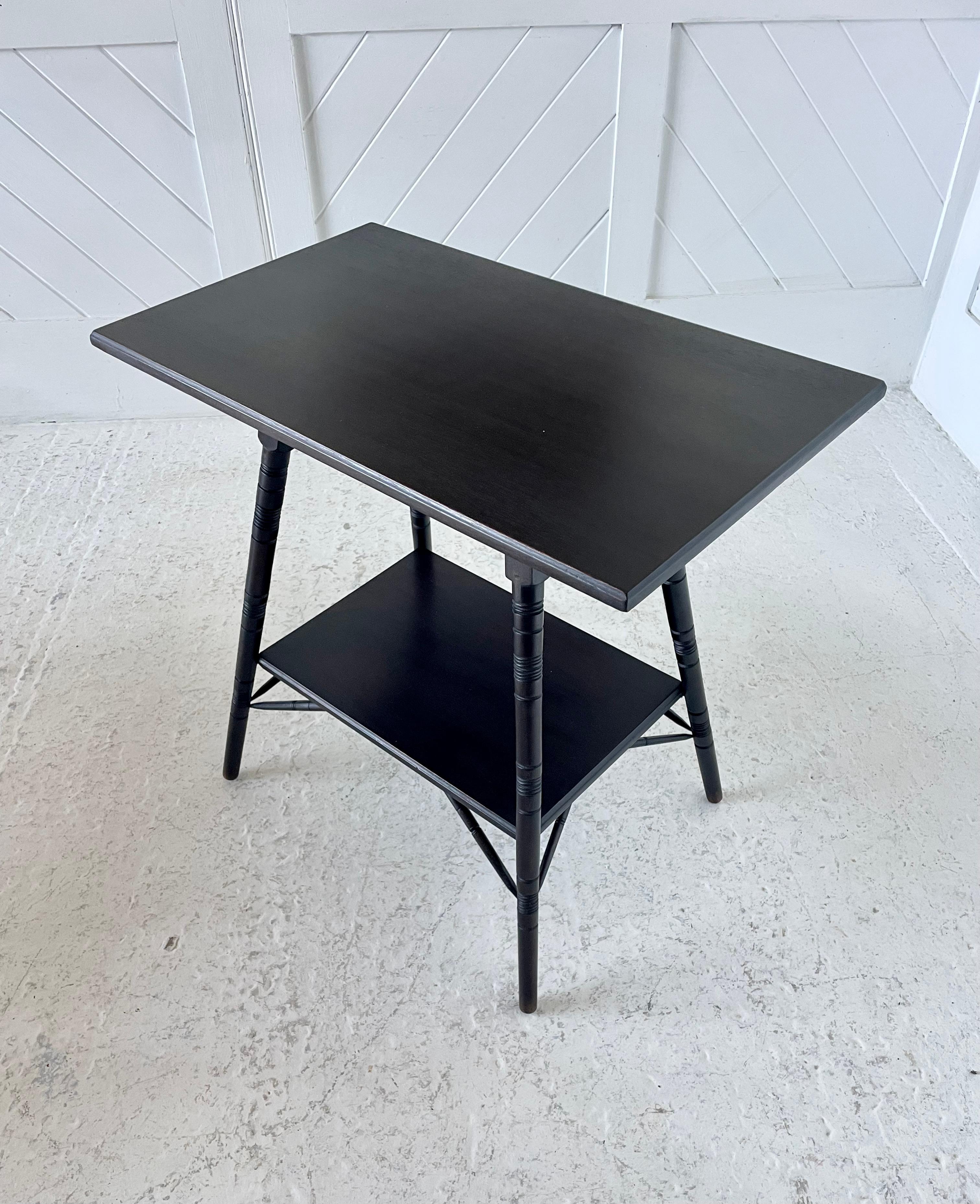Aesthetic Movement ebonised Mahogany side table, rectangular top with moulded edge, under tier shelf with turned incised legs and turned supports. In the style of E.W. Godwin possibly made by Liberty & Co or a similar retailer / manufacturer. The
