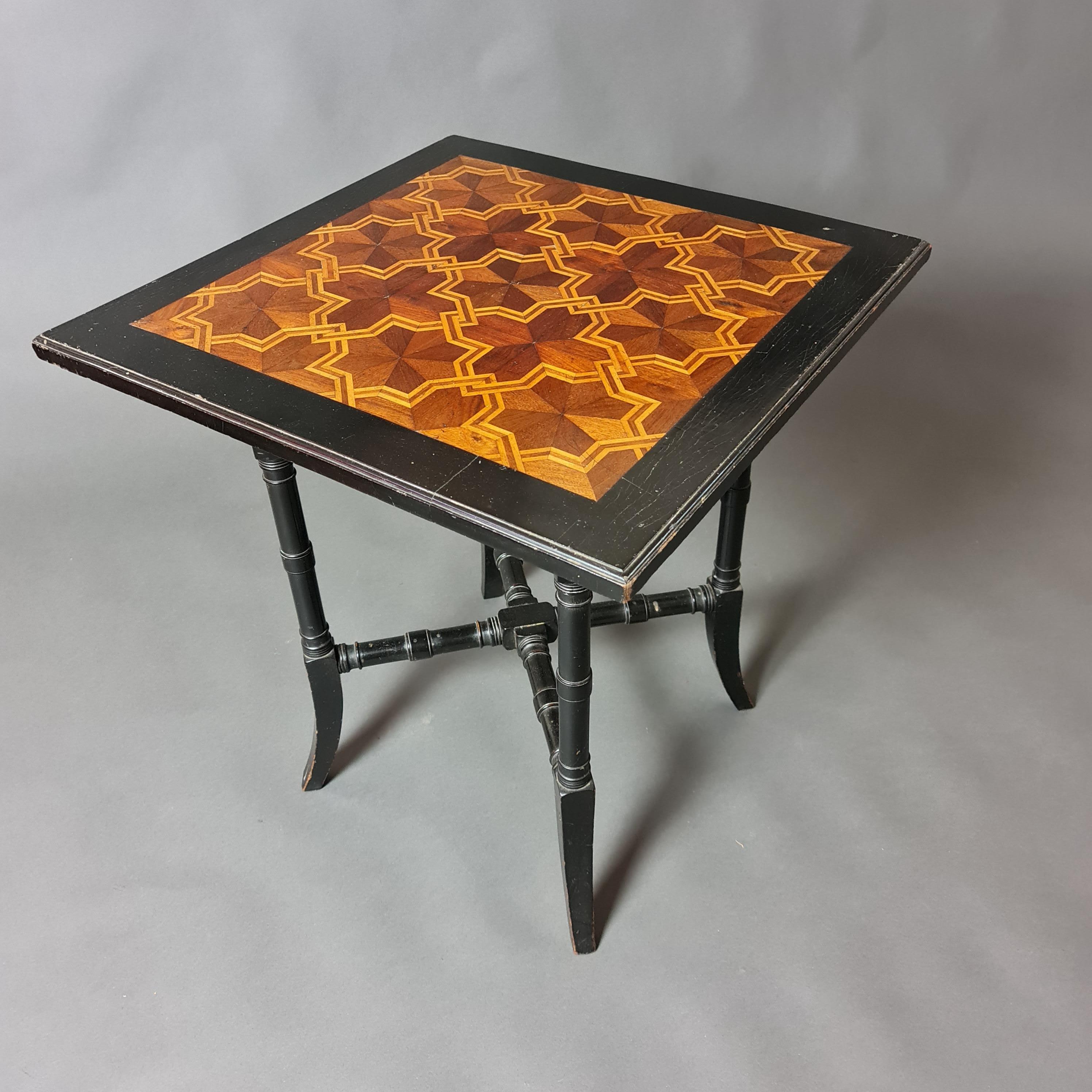 Mesa ebonizada Aesthetic Movement con tablero de parquet decorativo de maderas contrastadas. Esta tabla data aproximadamente de 1880  Se desconoce el fabricante, pero es de buena calidad; posiblemente sea de Howard and Sons de Londres, conocidos por