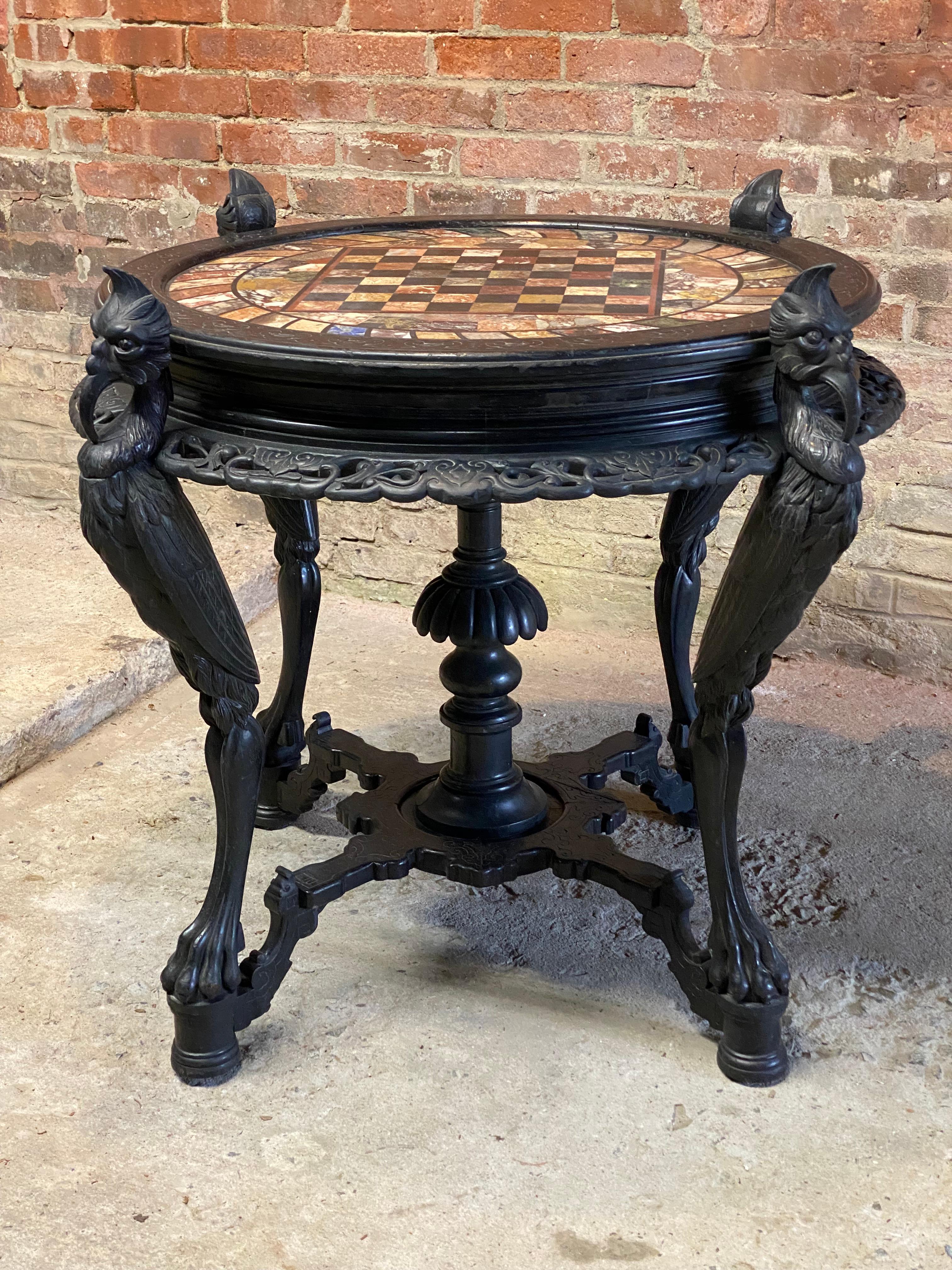 Outstanding ebonized specimen top chess table. This one of a kind find has all the bells and whistles of the ultimate luxury game table. Featuring the spectacular marble and semi-precious stone inlaid specimen chess board top, four carved feathered