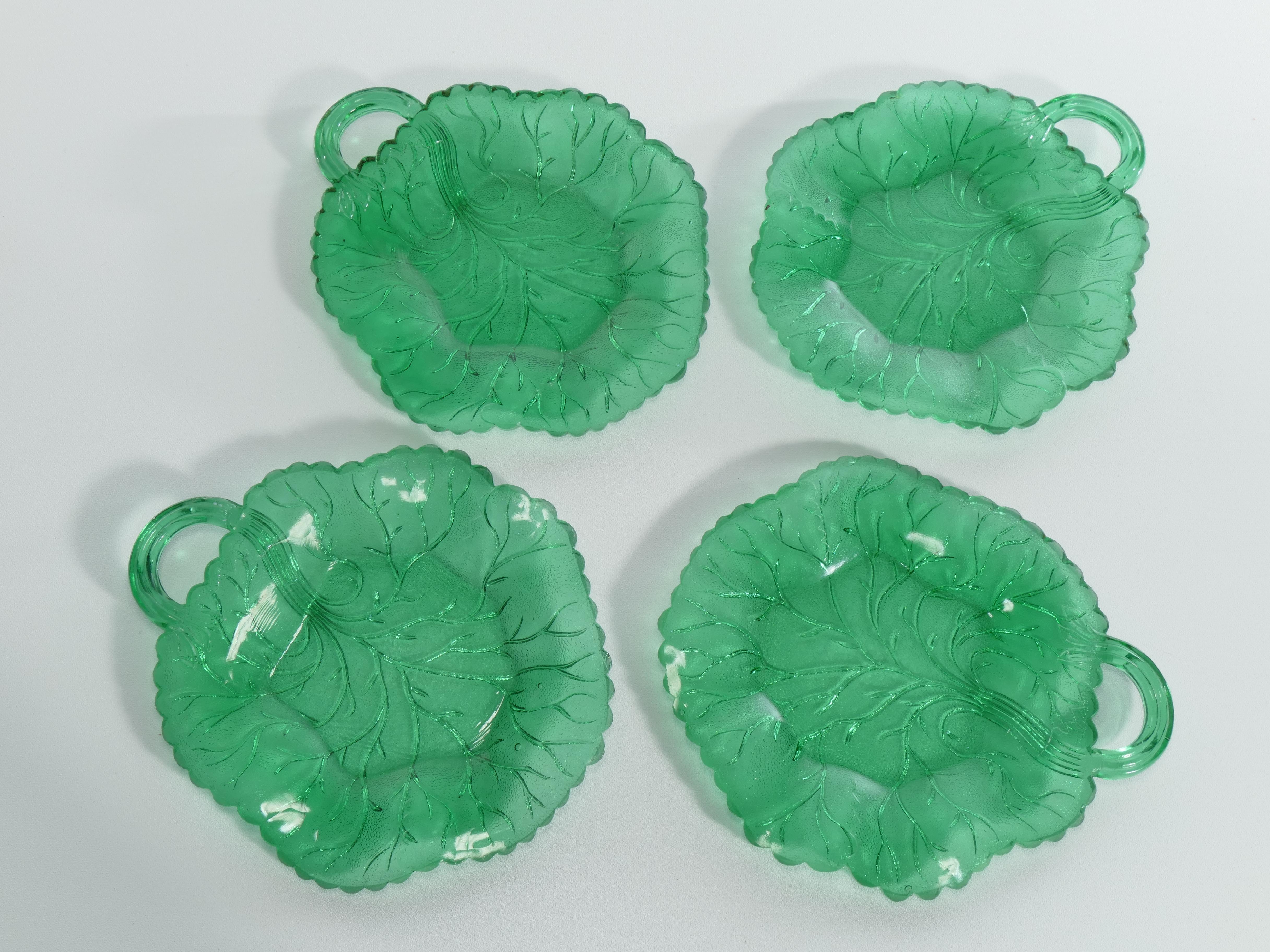 Discover the epitome of elegance and refinement with our exquisite collection of a set of 4 emerald green glass leaf plates. 

The delicate green glass, reminiscent of lush foliage, lends a touch of nature's splendor to your dining experience. The