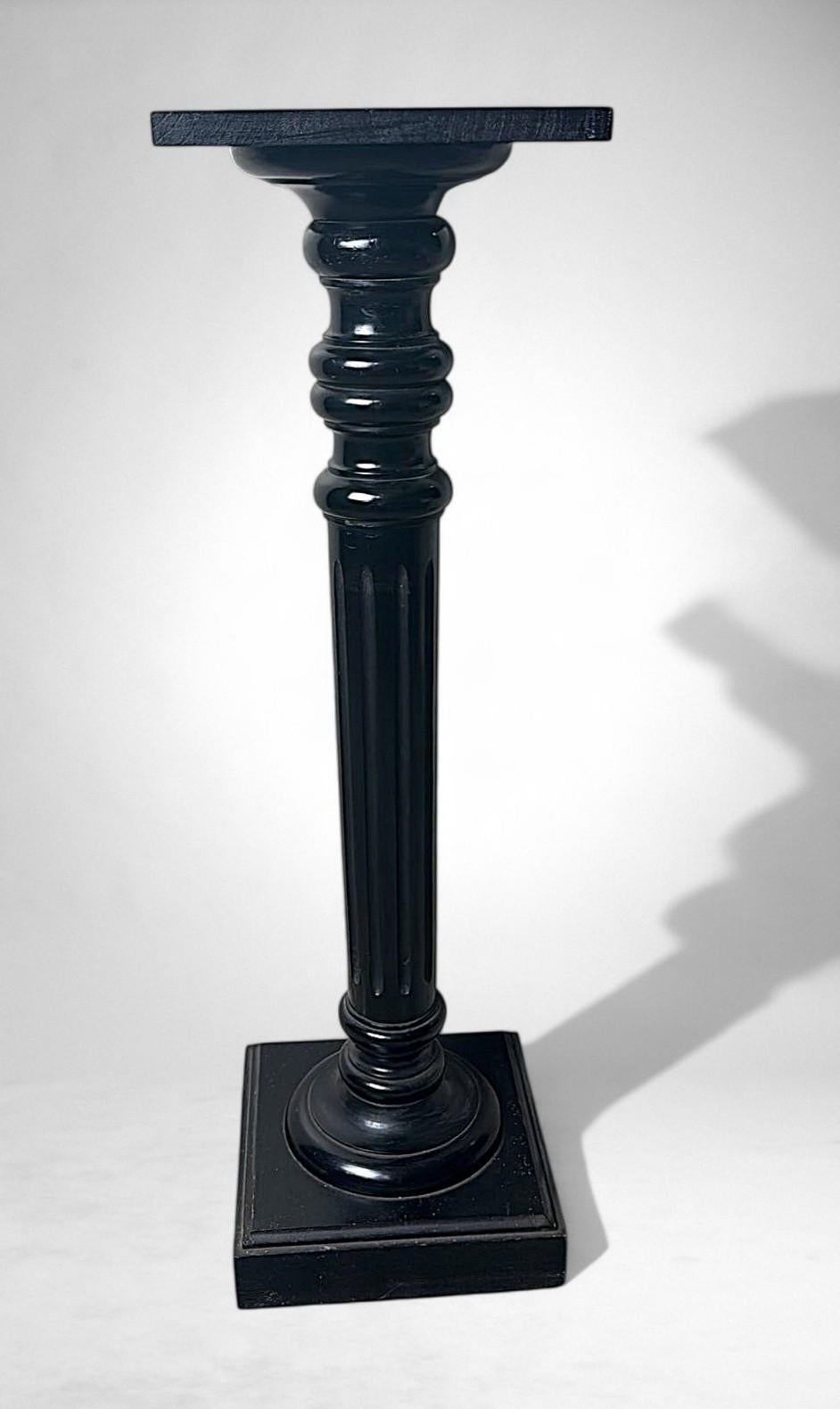Elegant French pedestal in ebonized walnut, featuring a finely turned column resting on a square base, with a matching square top. A piece of refined simplicity and timeless appeal, its strong yet harmonious lines highlight its sophisticated