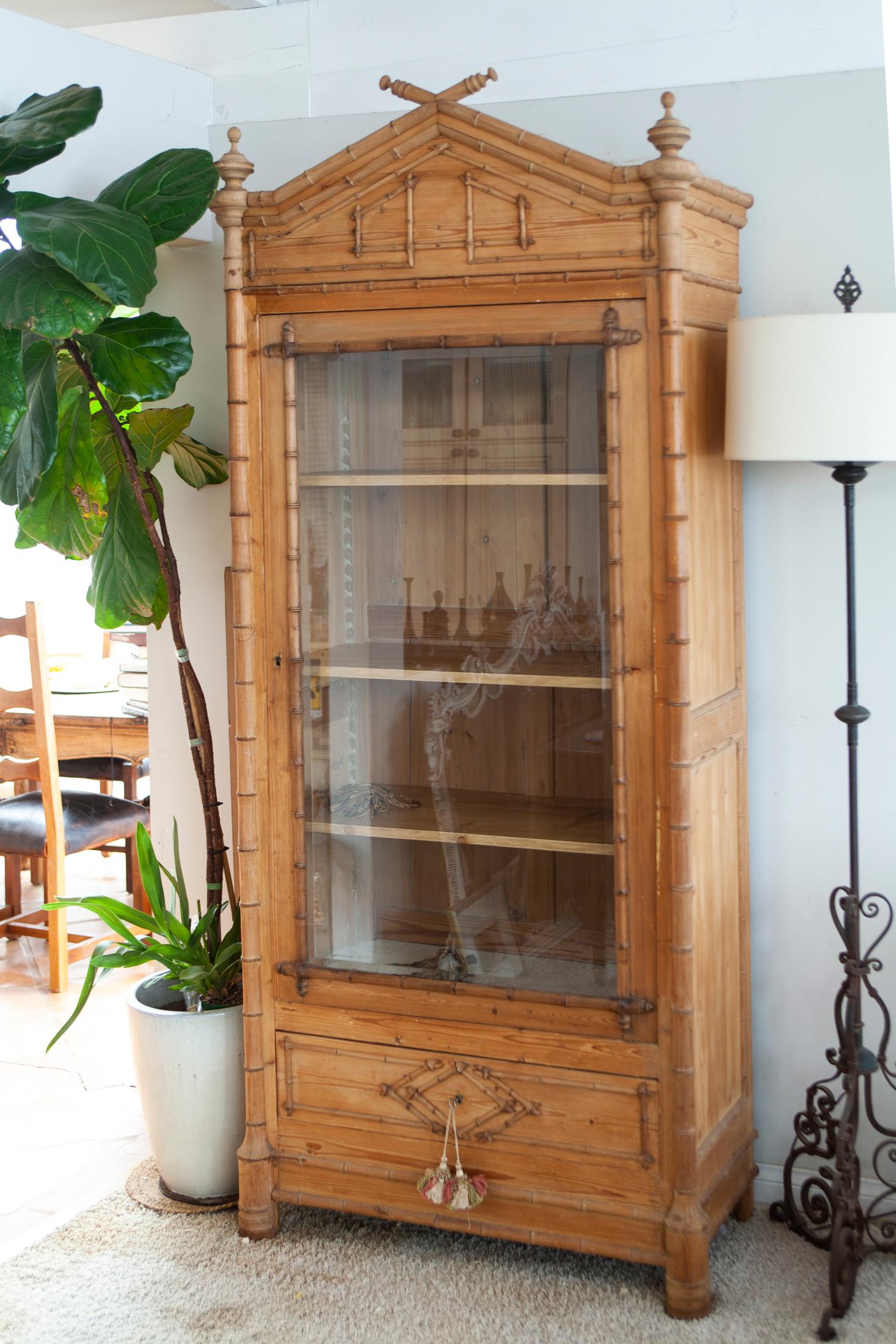 19th century French pine & cherry faux bamboo armoire.
A pine pitched piece with hand turned cherry wood appliqued trim & moldings 
 with simple paneled sides.
The case has a single drawer beloved the beveled glass door panel flanked by hand