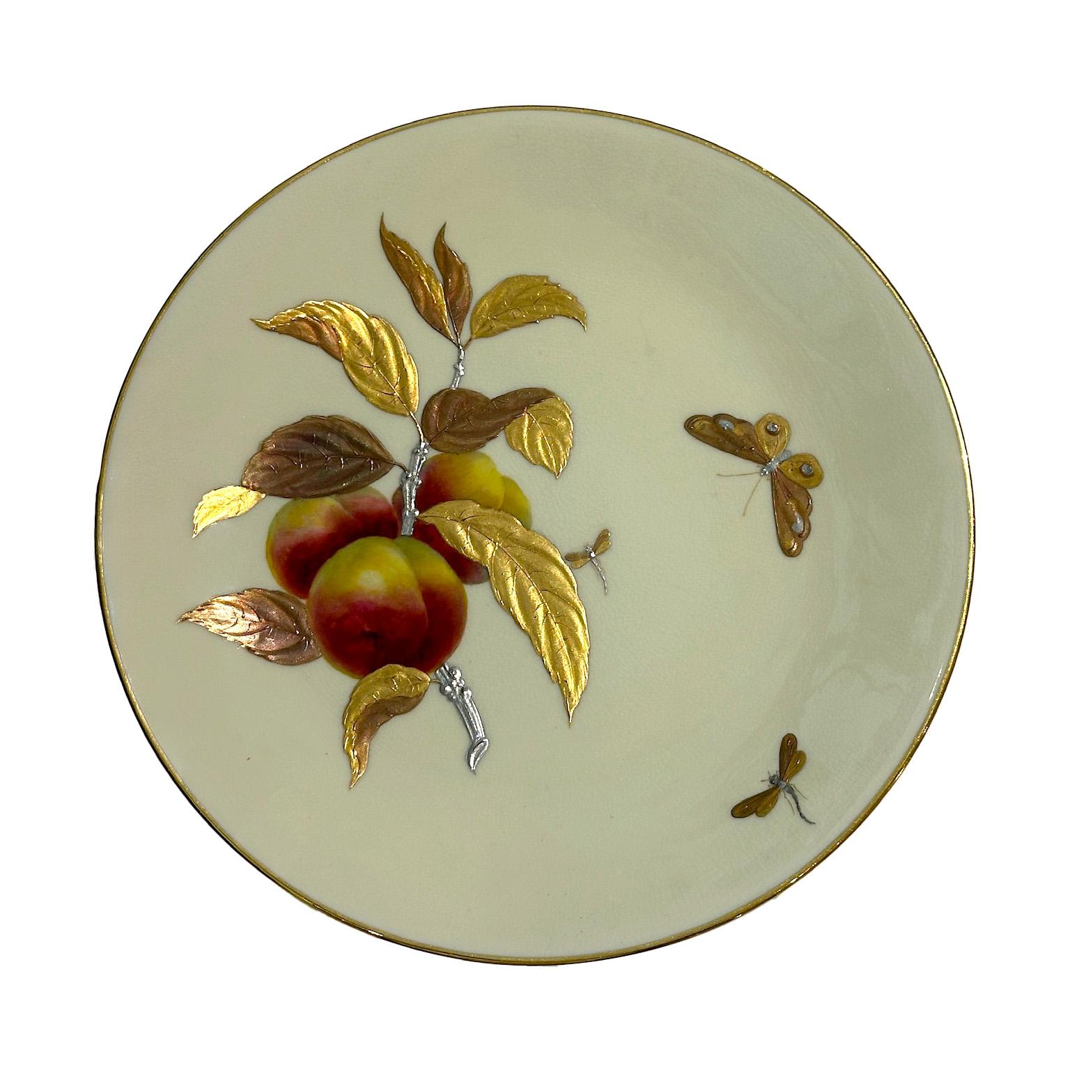 Este magnífico plato de porcelana firmado por Minton, fechado en 1880, encarna el refinamiento artístico del Aesthetic Movement. Finamente decorada a mano, presenta motivos en relieve de hermosos melocotones que cuelgan de una rama elegantemente