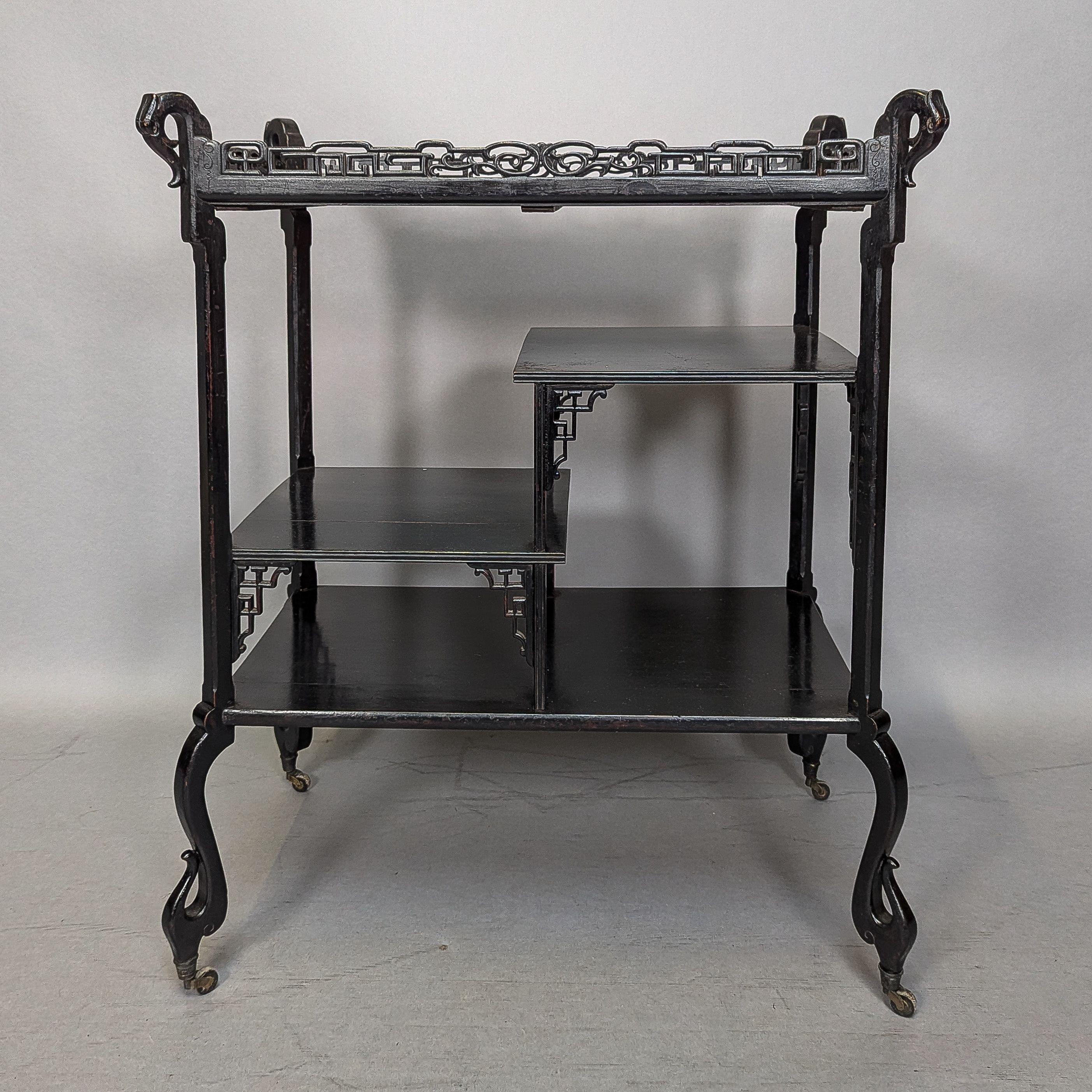 Gabriel Viardot, Stil von. Ein Teewagen der Ästhetischen Bewegung mit einer Galerie aus Laubsägearbeiten im japanischen Stil und erhabenen Tierköpfen an jeder oberen Ecke sowie einer Flussszene mit Reihern auf der Oberseite. Gestufte Regale im