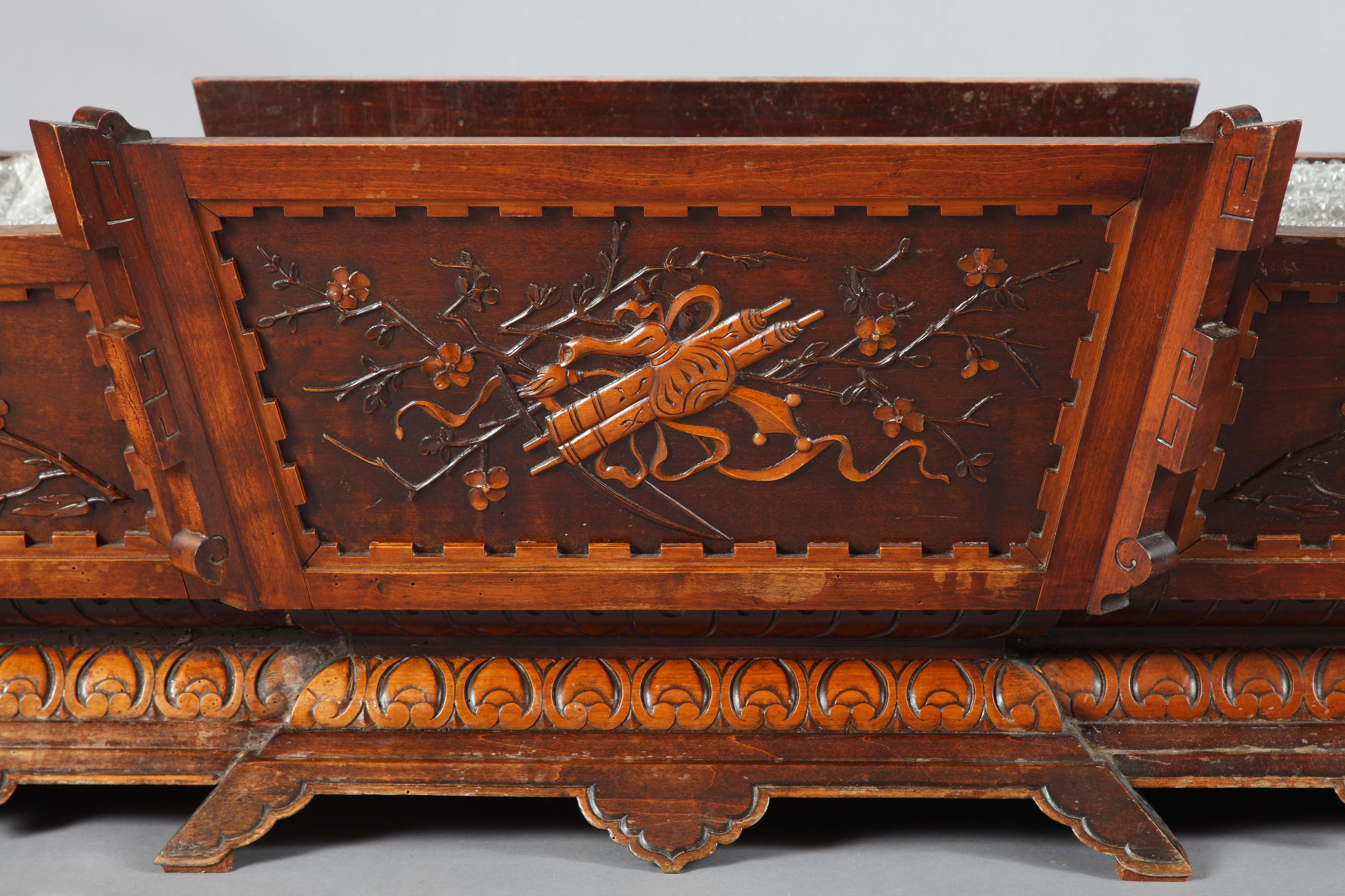 A large Japanese style boat-shaped jardiniere attributed to G. Viardot, made in carved wood, ornated with panels decorated with Japanese blossoming cherry tree branches and a trophy of musical instruments.

Gabriel Viardot career began as a wood