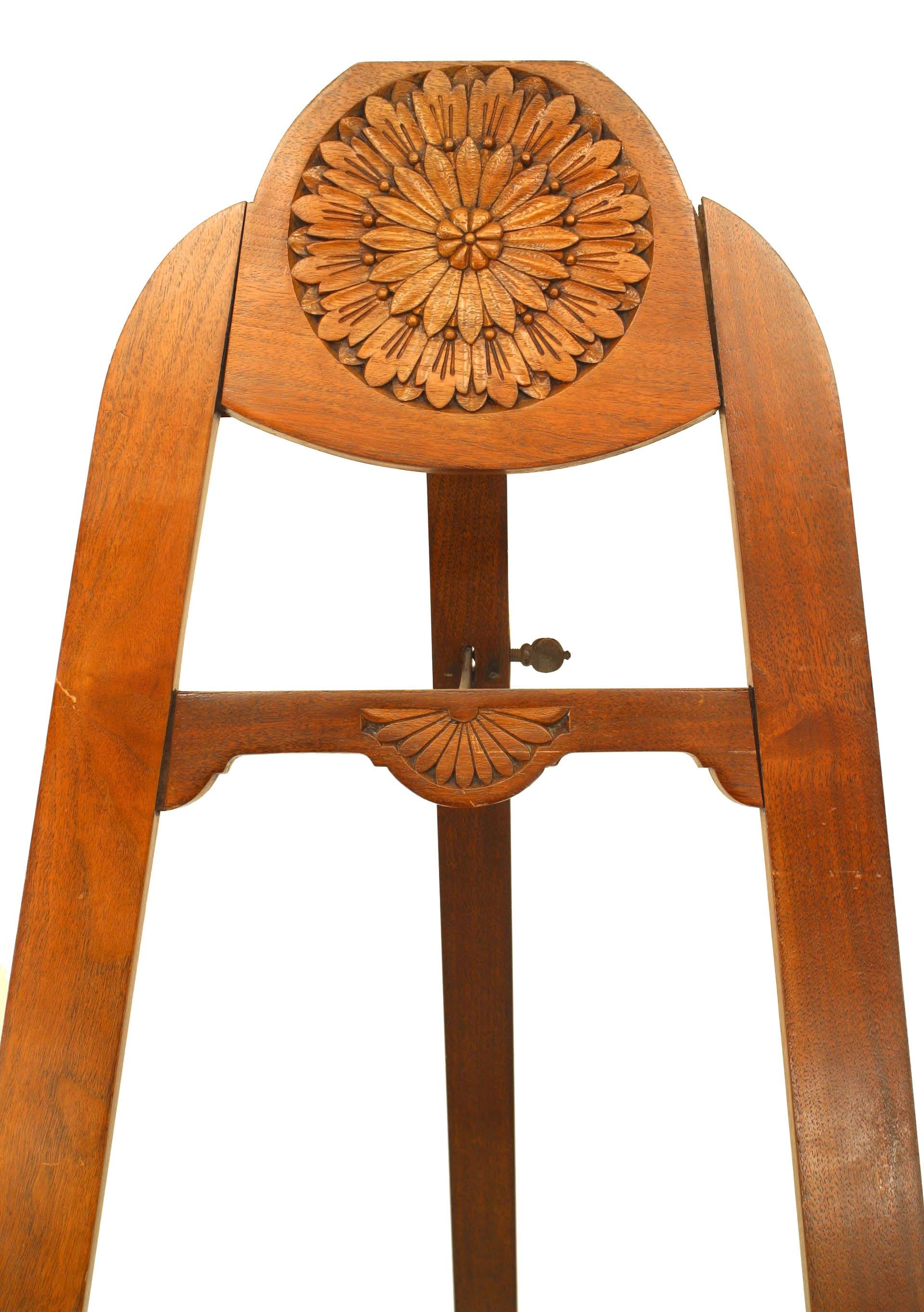 English Aesthetic Movement light mahogany standing easel with a carved round sunflower pediment top.
 