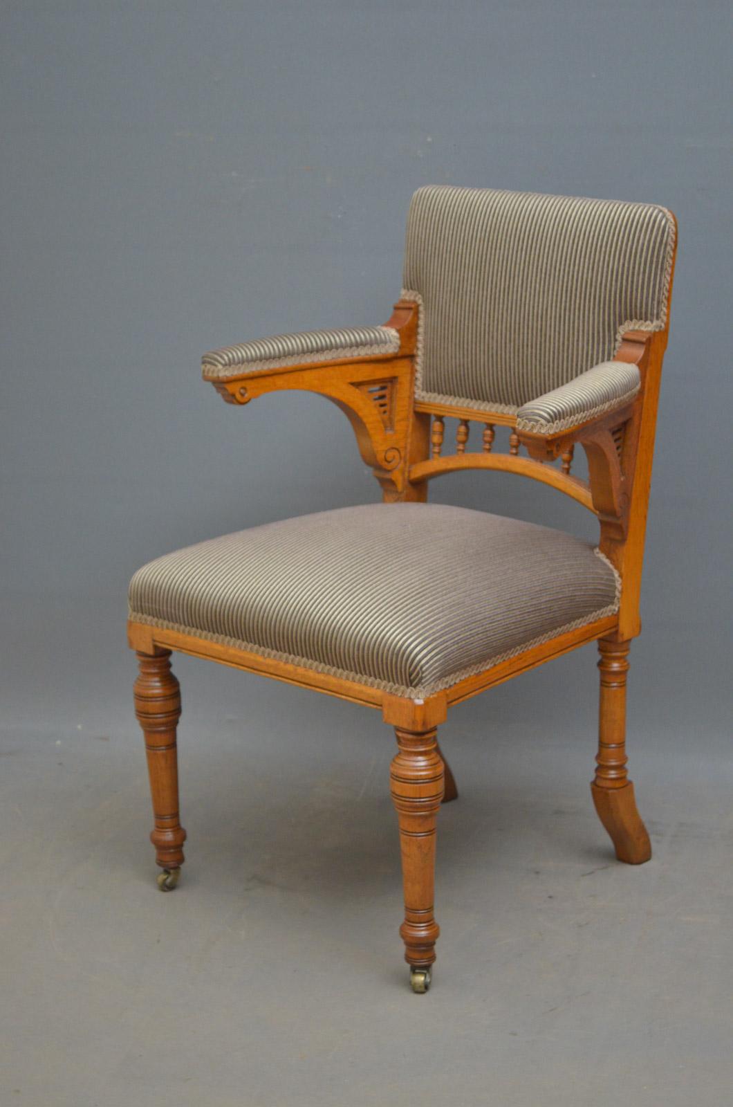 Sn4424 Victorian - Aesthetic Movement office chair in oak, having upholstered back with turned spindles below, open padded arms and generous, sprung seat, standing on turned legs and brass castors. This antique chair is in excellent home ready