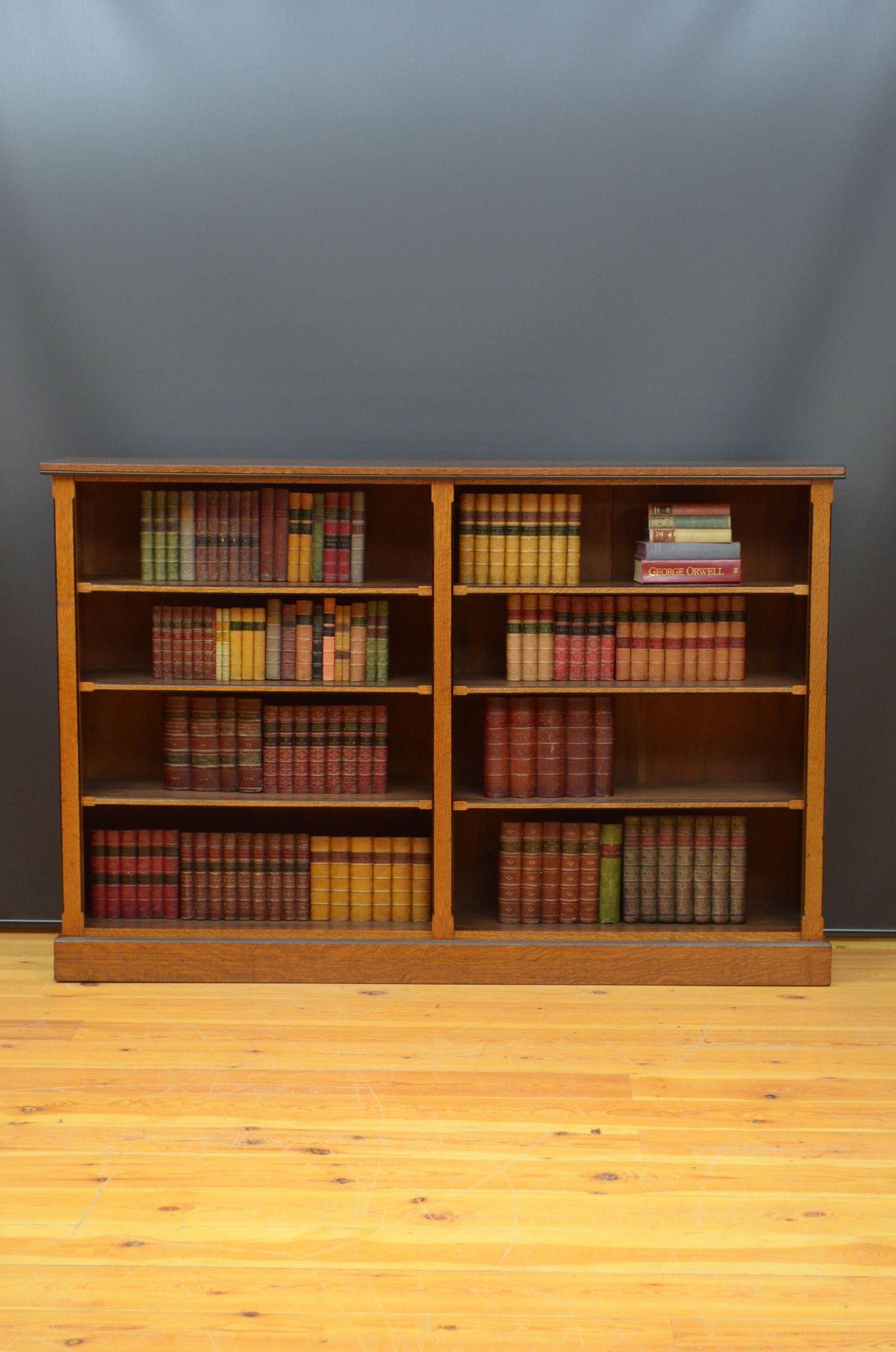 R034 Attractive Victorian open bookcase in oak, having oversailing top with canted and ebonised edge above two open sections each with three height adjustable shelves, flanked by canted and ebonised pilasters, all standing on plinth base. This