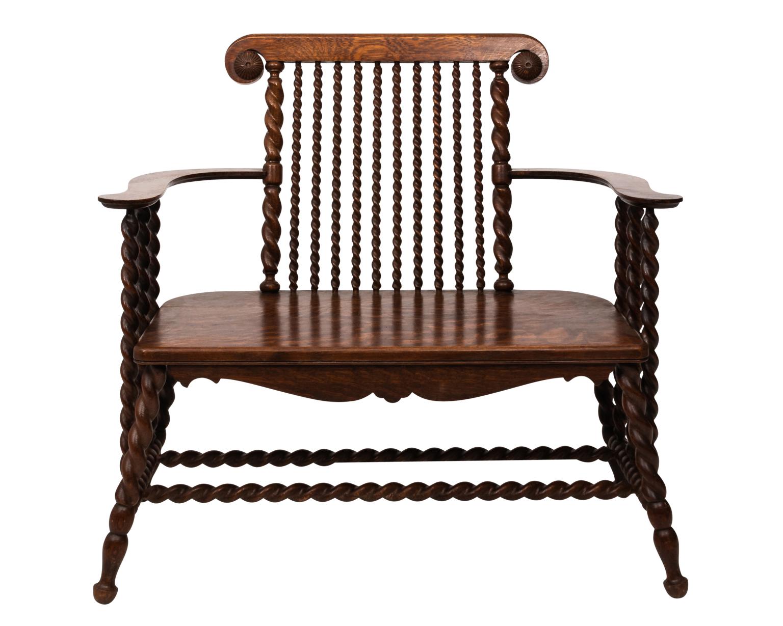 Beautifully handcrafted dark oak two-seat bench with curved flat armrests supported by turned barly twist columns, circa 1900s.
 