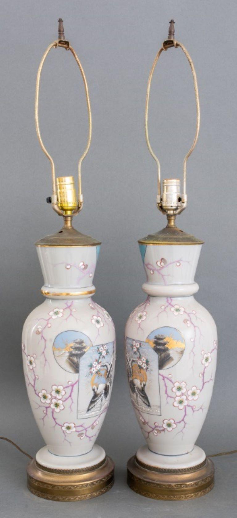 Paire de vases balustres en porcelaine céramique du mouvement esthétique japonais, peints à la main de motifs de fleurs de cerisier et de hérons, aujourd'hui montés comme lampes de table et reposant sur des bases en métal doré. 
