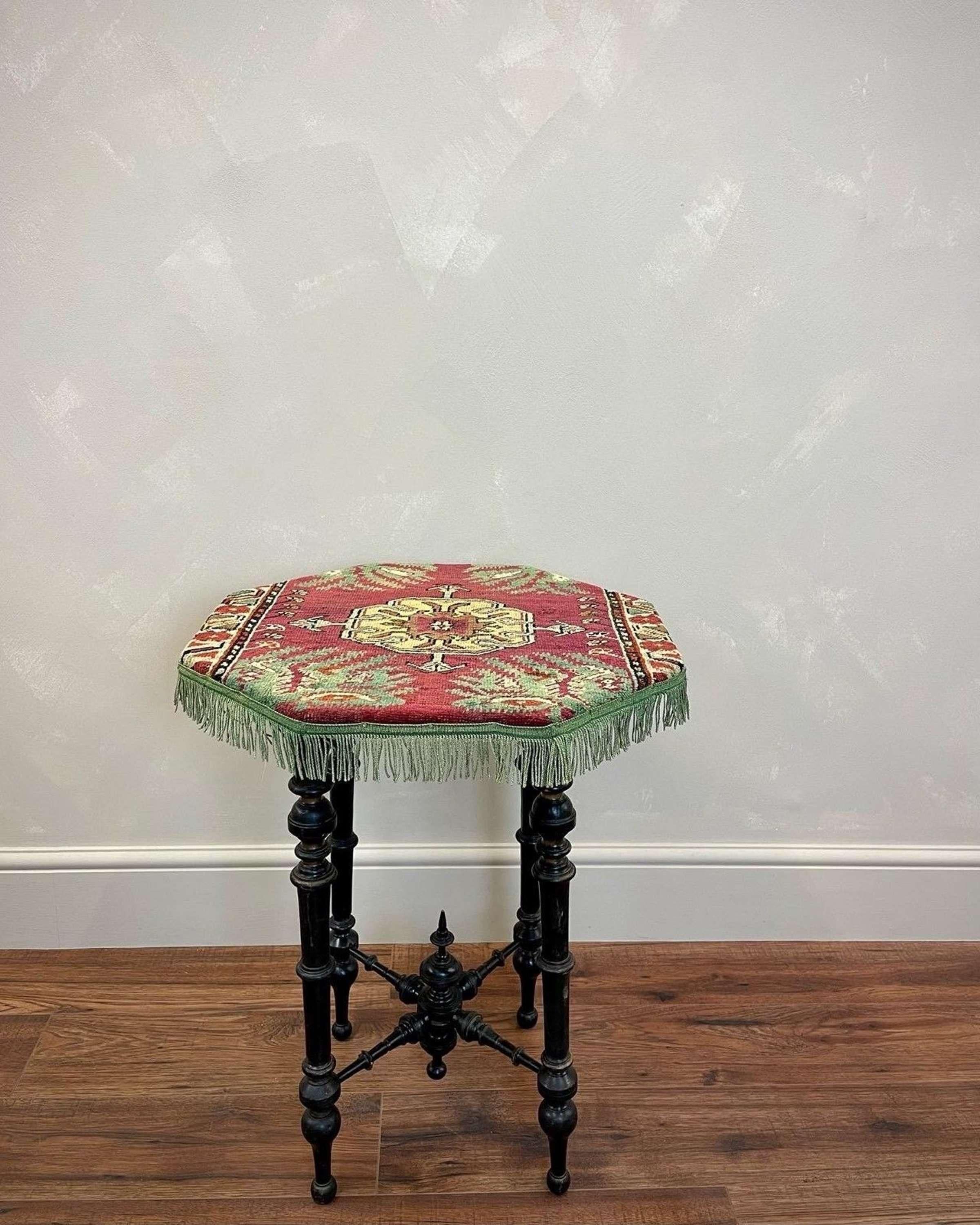 Lovely country house piece. Octagonal aesthetic movement side table, with later vintage carpet top and fringing which is in good order for use 
Ebonised and gold intricate woodwork throughout 
Intricate turnings and impressive lower finial.
Works