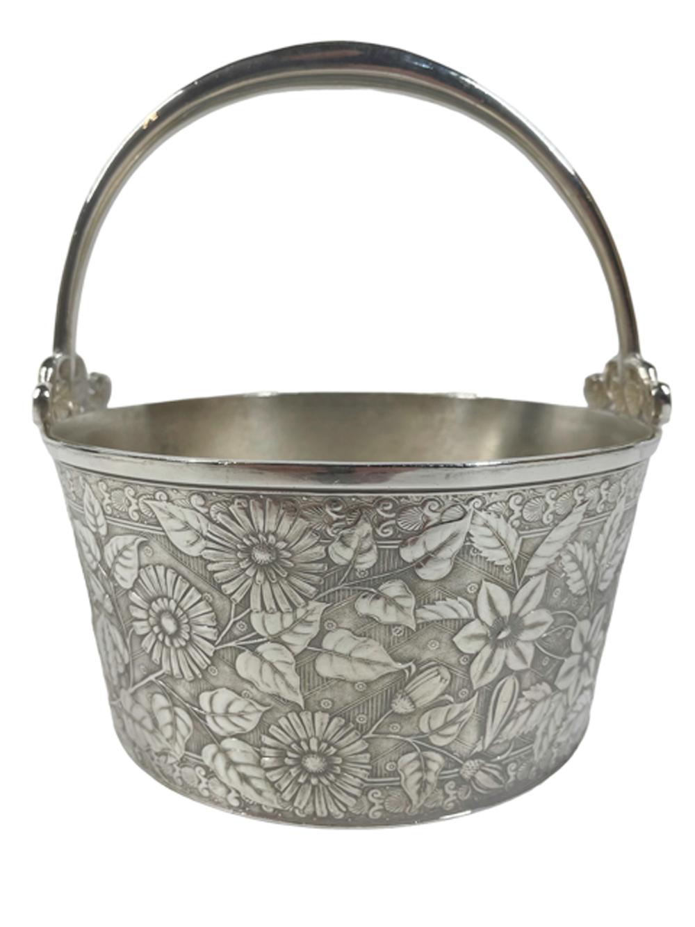 American Aesthetic Movement ice bucket in silver plate by Meridan. The tub form bucket with allover chrysanthemum pattern to the exterior and a removable strainer plate and fixed handle with scrolled leaf terminals.