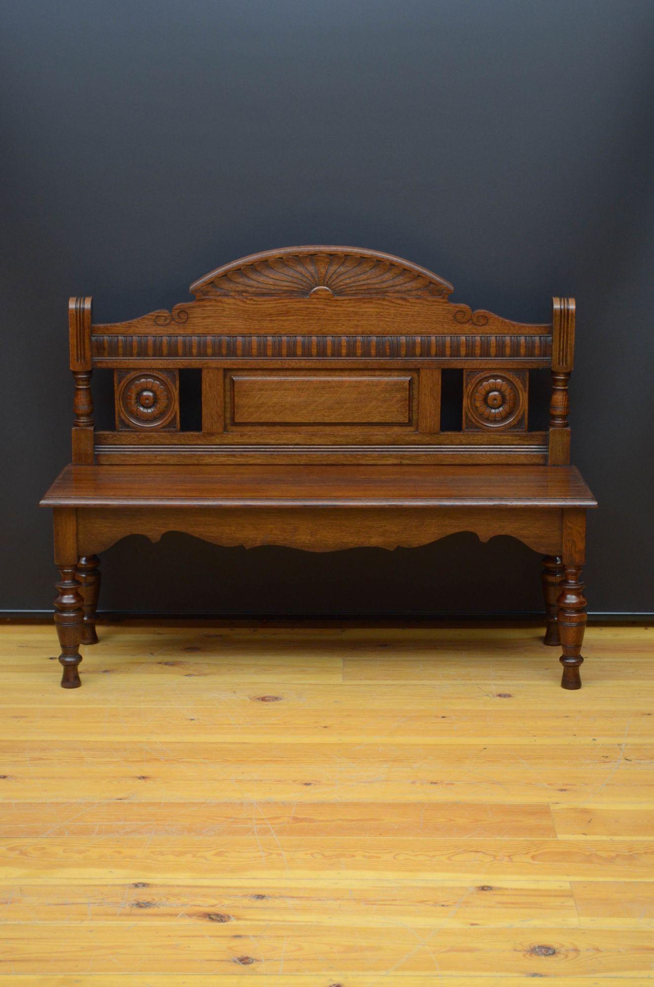 Sn5530 Stylish Aesthetic Movement Victorian hall seat in solid oak, having shaped and sunrays carved back with gadroon carving and two carved sunflowers above a solid oak seat with moulded edge, all standing on turned and carved legs united by