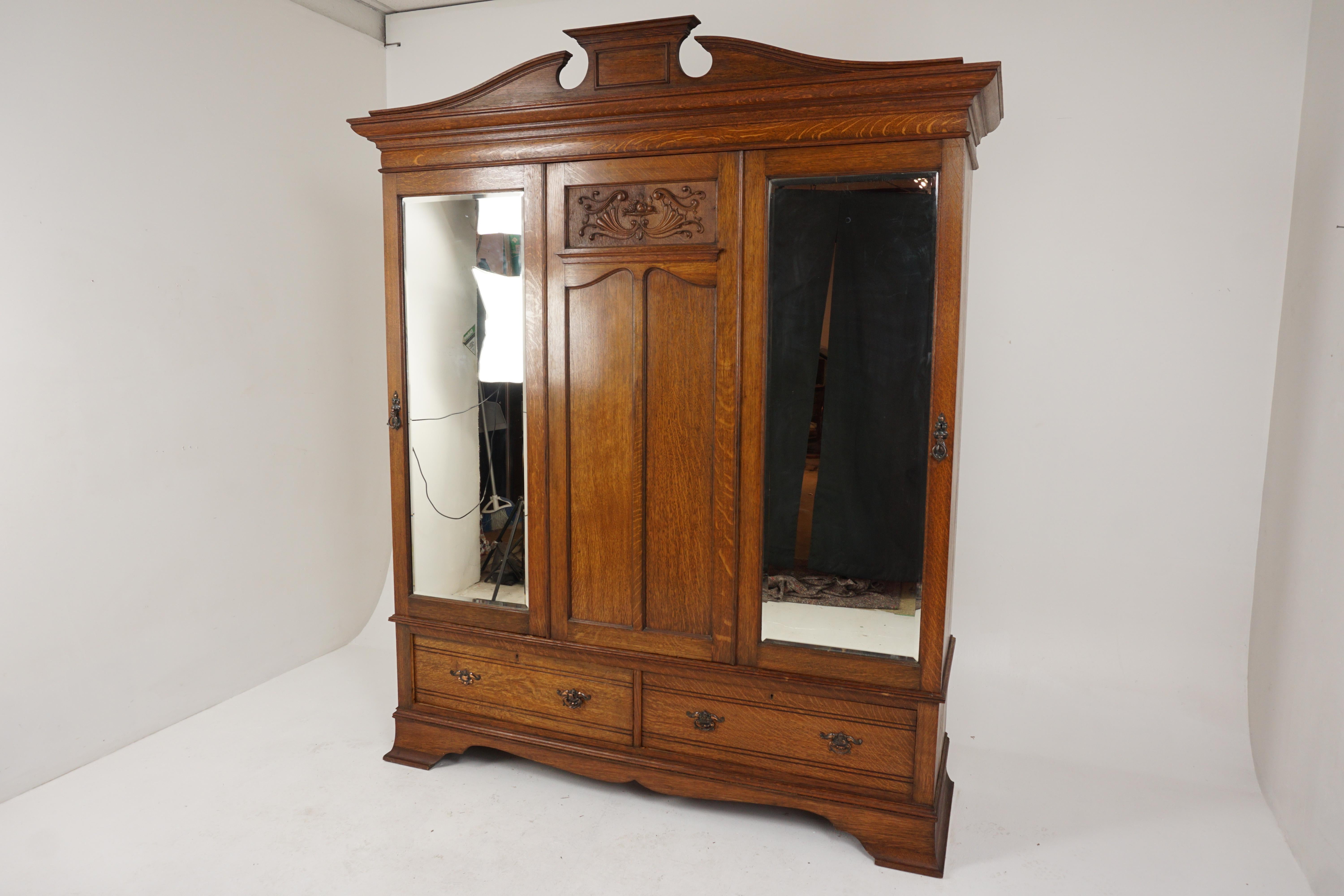 Aesthetic movement tiger oak armoire, Maple + Co. London, England 1900, H539

England 1900 
Solid oak
Original Finish
Moulded cornice on top
Carved paneled center doors
Flanked by a pair of beveled mirrored doors
Fitted interior with brass rod and