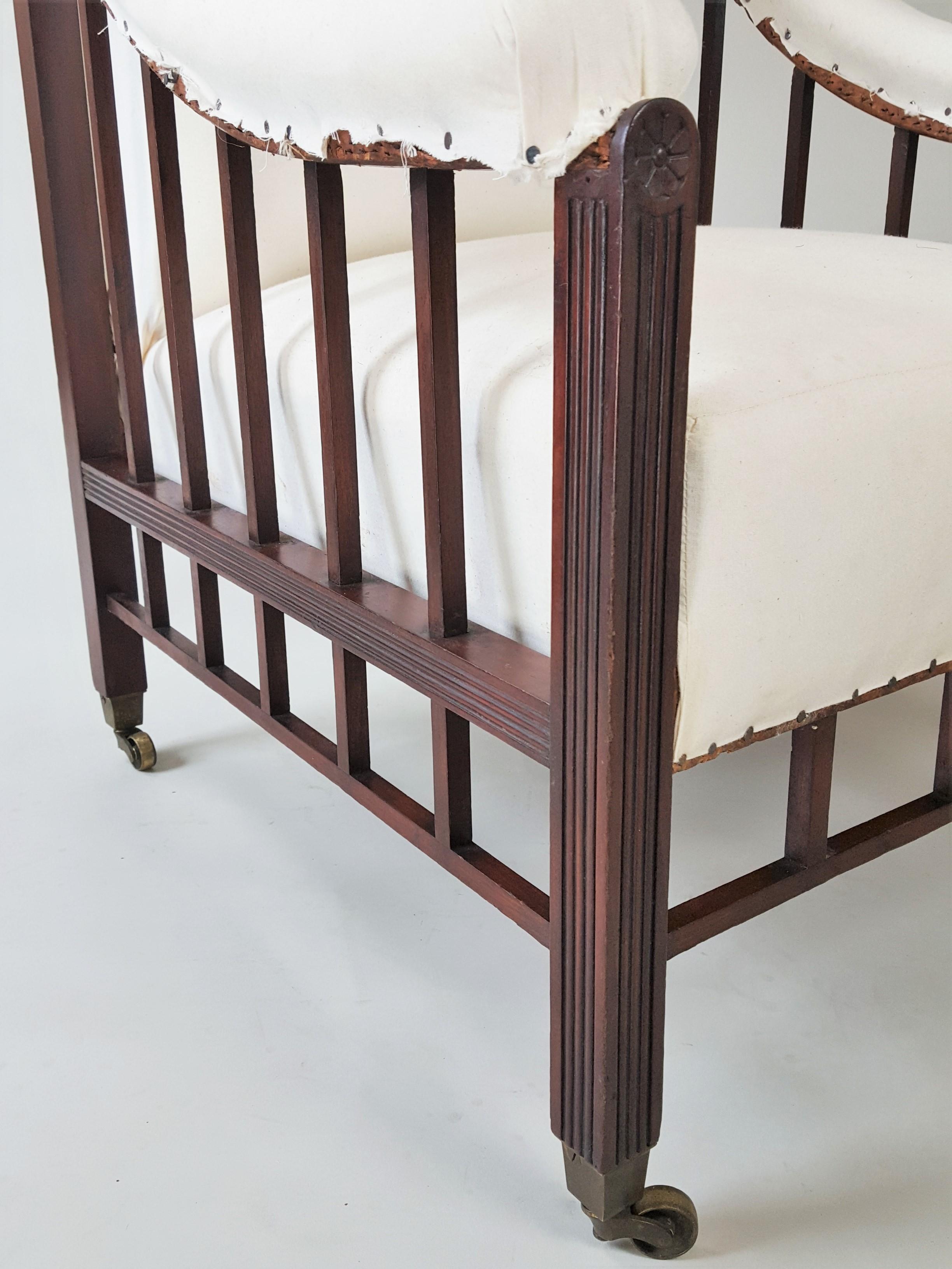 Poltrona Aesthetic Movement imbottita in mogano di alta qualità del 1880 circa. La sedia ha un design elegante, con i suoi ampi braccioli e la sua lavorazione del legno finemente rifinita. Ha le rotelle originali in ottone ed è stata tappezzata di
