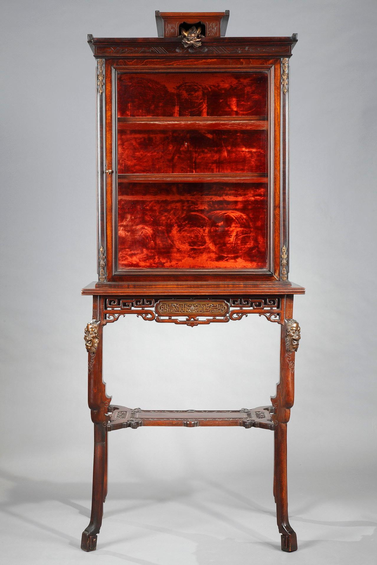Beautiful Japanese style vitrine made in carved and engraved tinted alder, attributed to G. Viardot. It opens on the upper part with a door revealing two shelves on a crimson velvet background, framed by pilasters adorned with decorative patinated