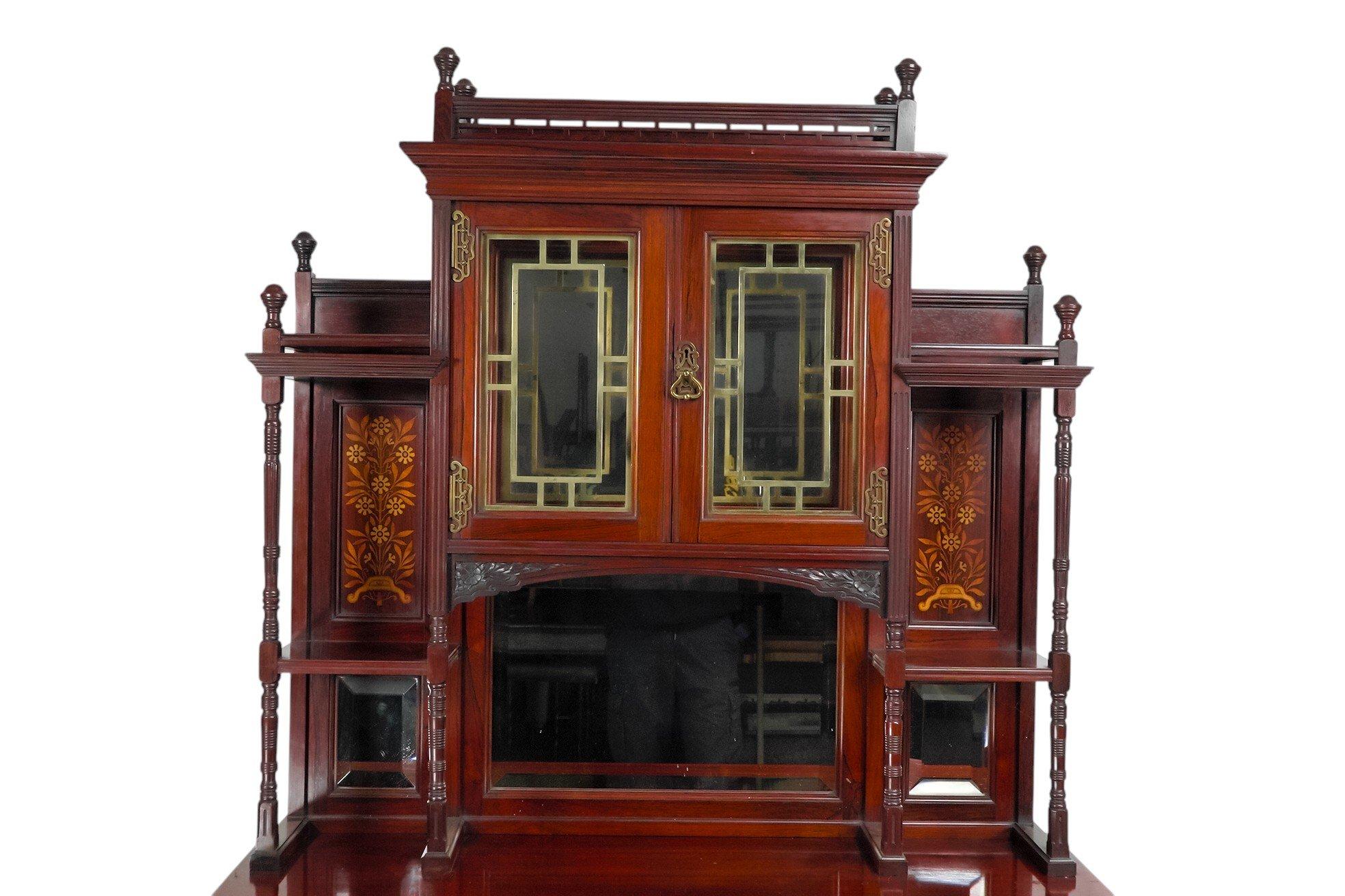 Henry William Batley zugeschrieben, wahrscheinlich für Gillows of Lancaster. Ein Nussbaumschrank der Ästhetischen Bewegung mit feinen Abschlüssen und einer Laubsägearbeit-Galerie an der Oberseite, über einem verglasten Schrank, der von oberen