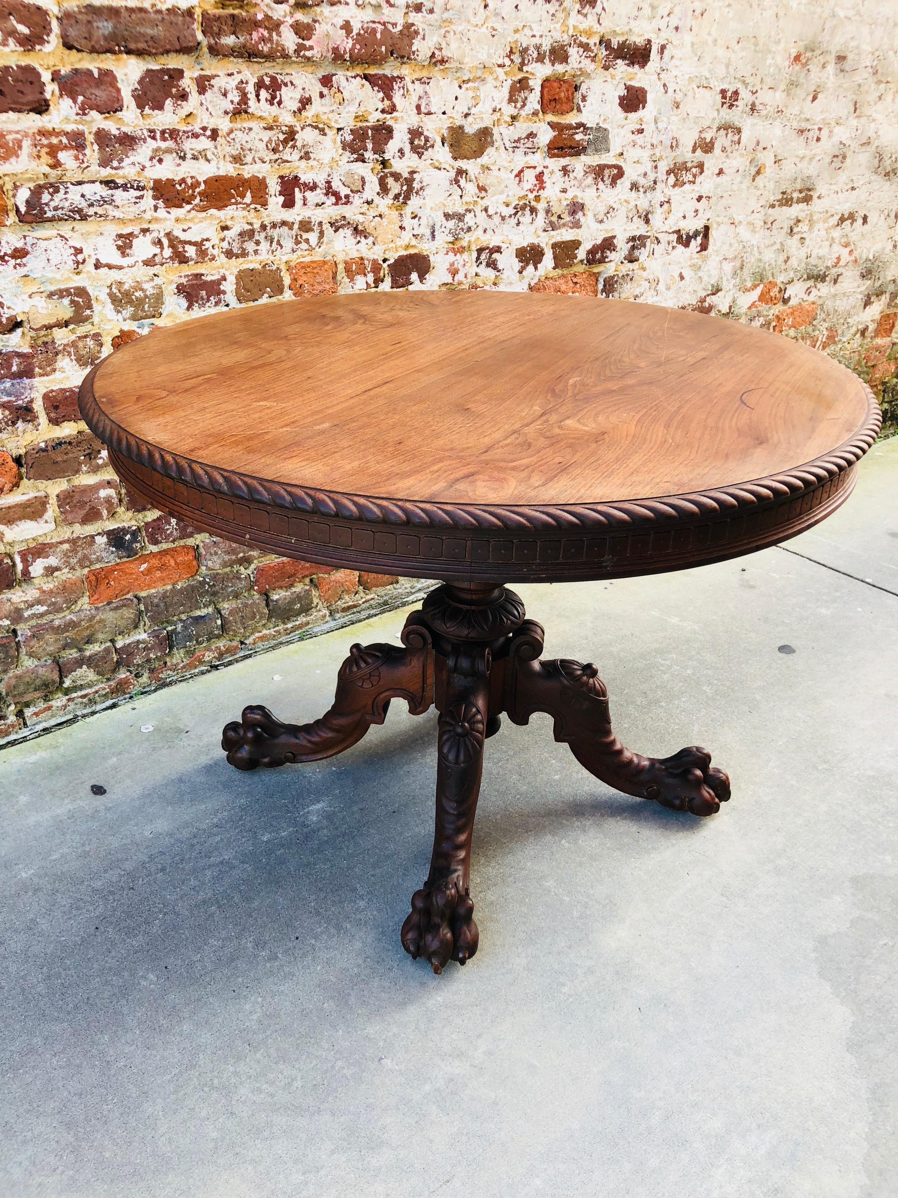 Aesthetic movement walnut centre table with ornately carved paw foot base and nice ropes edge on top.