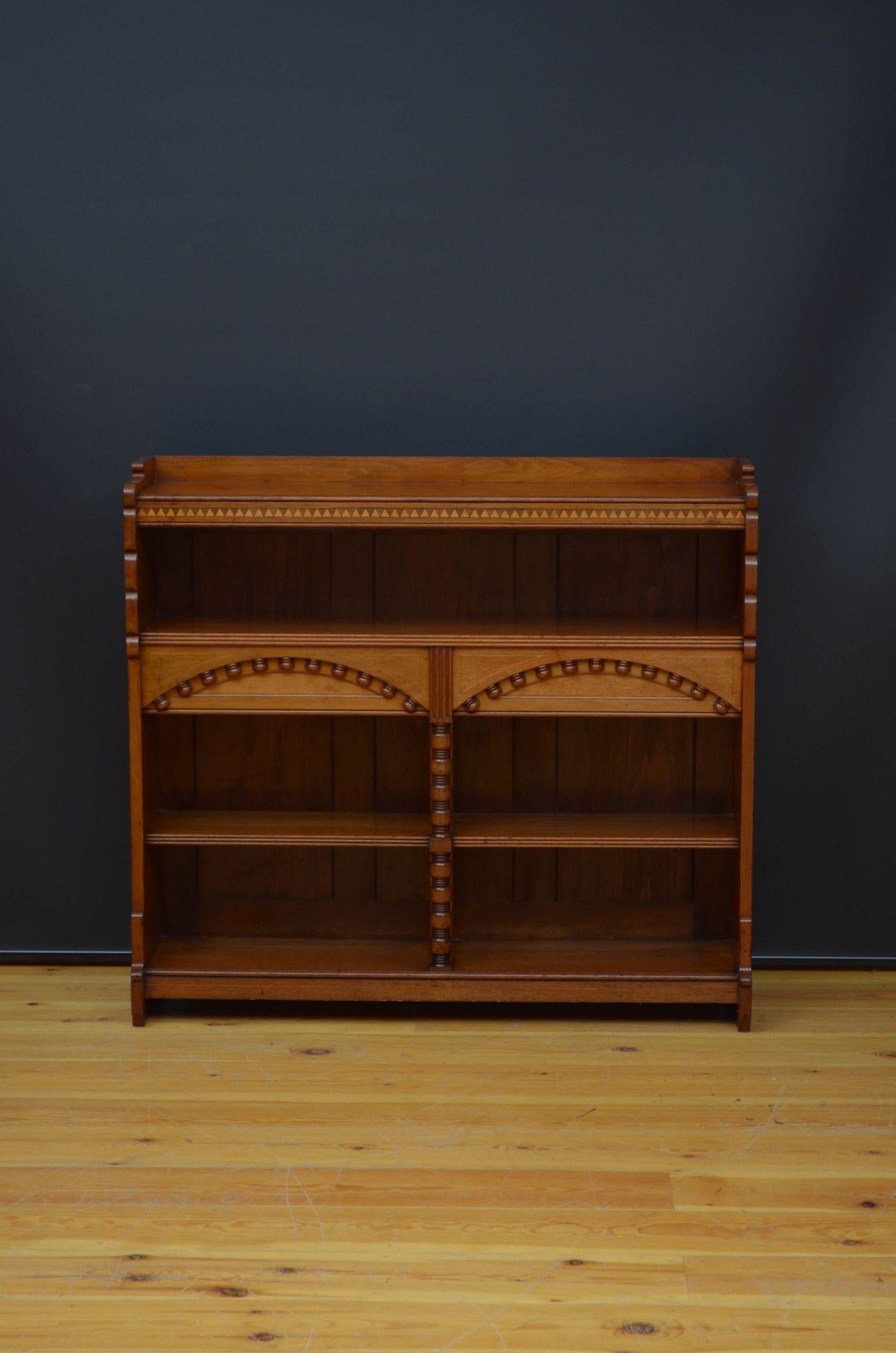 Sn5449 An interesting Aesthetic Movement, Victorian open bookcase in walnut, having raised gallery to the string inlaid top above dog tooth inlaid frieze and long open section with two smaller open sections below, all with very decorative, carved