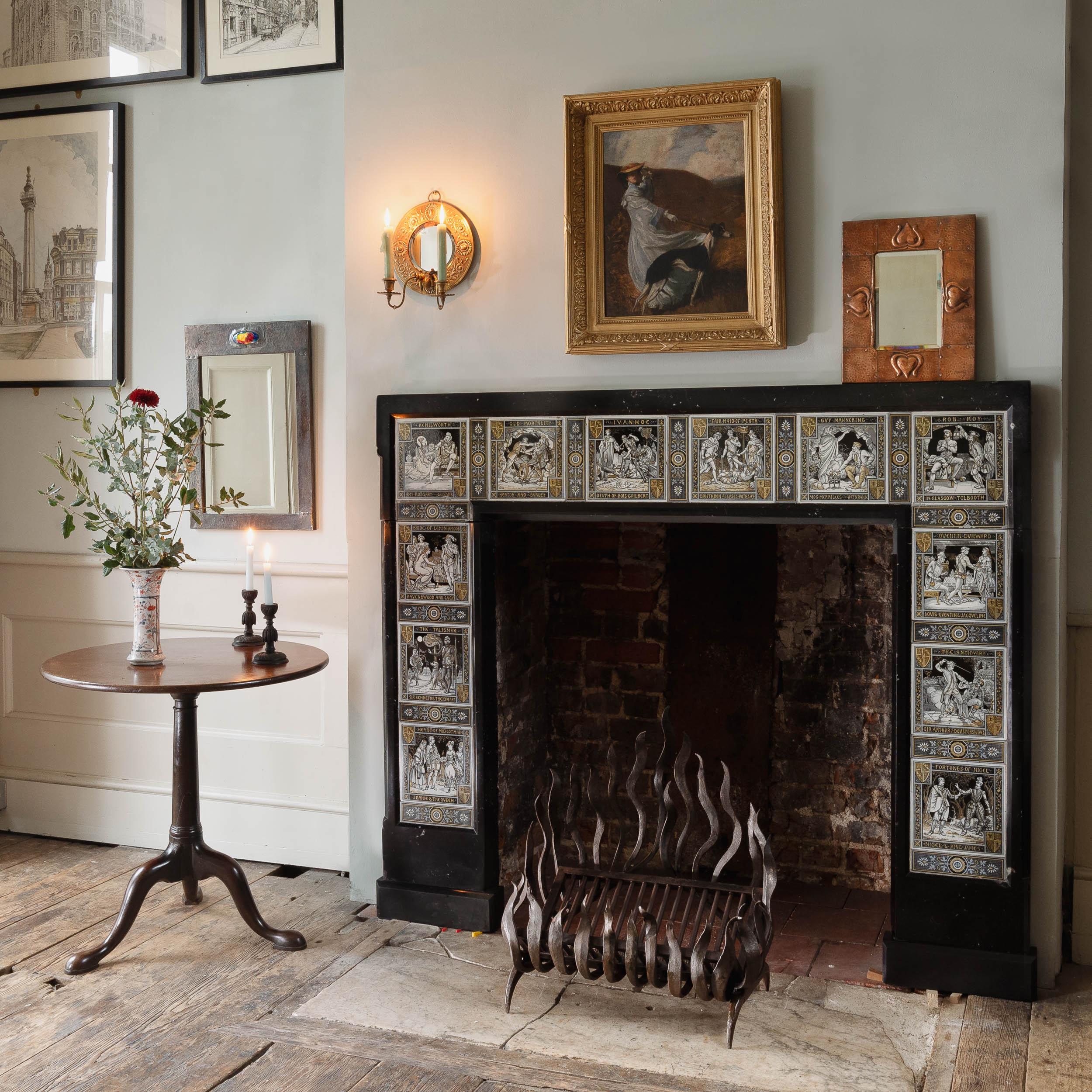 Une cheminée esthétique d'époque en marbre de Kilkenny insérée dans des carreaux de Minton, a été retirée de la maison de Cornouailles du célèbre romancier britannique John Le Carré.  L'encadrement en pierre fossile avec des moulures en arc de