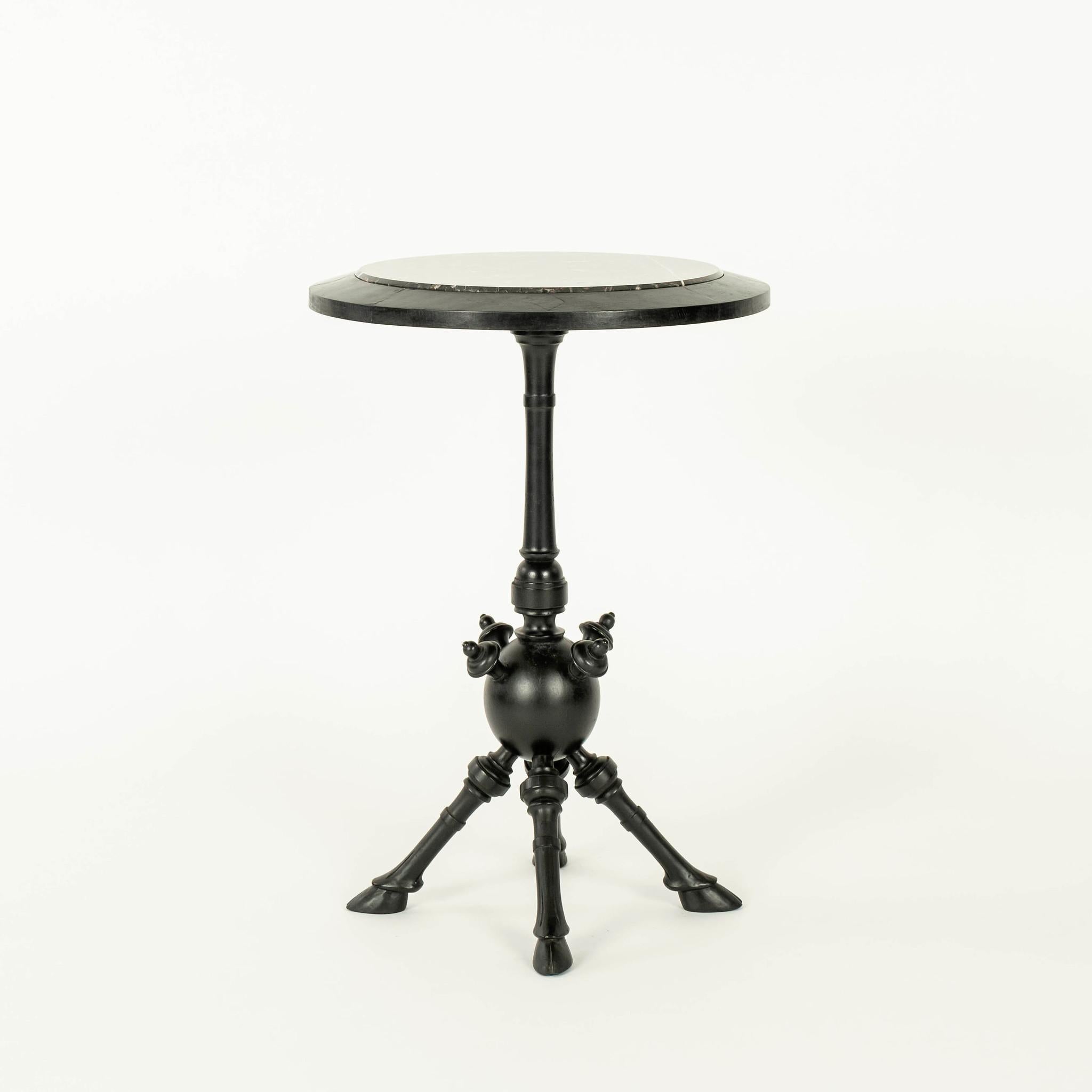 Einzigartiger Tisch im ästhetischen Stil, ebonisiert, mit schwarzer Marmorplatte und gedrechseltem, spindelförmigem Kugelsockel, der von vier handgeschnitzten, beschlagenen Beinen getragen wird.
 