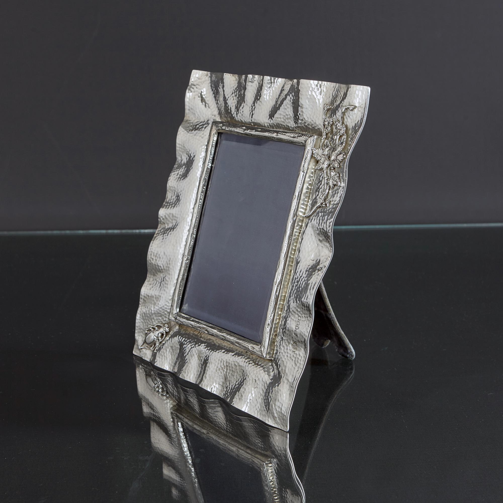 Rare and early Aesthetic style antique silver photograph frame from the late Victorian era. The border is hand hammered with a mottled effect. There is a cast central surround with a bark finish, a cast and applied beetle in one corner, and a spray