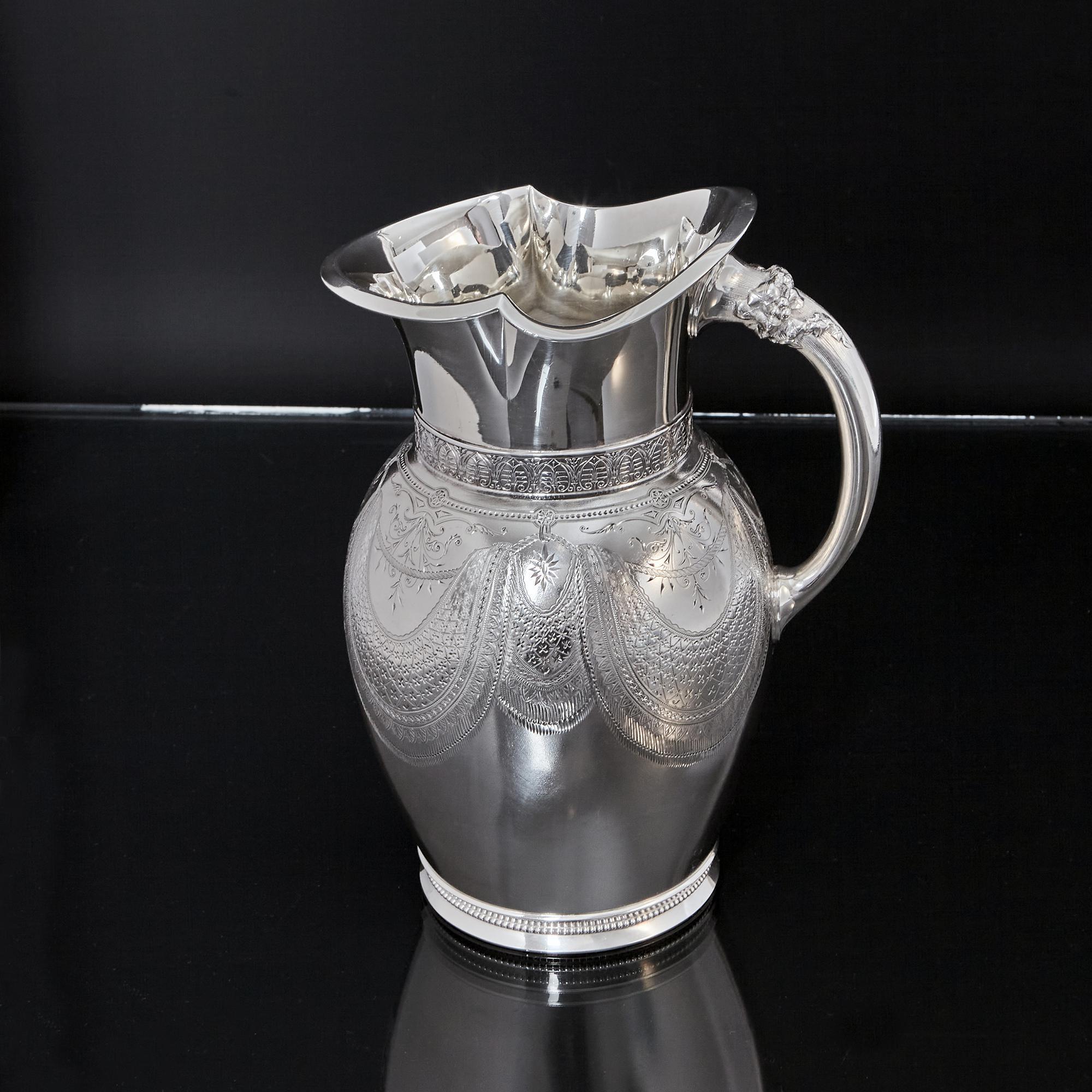 Beautifully crafted antique American sterling silver water jug in the Aesthetic style, with a frosted surface decorated with the most delicate hand-engraved swags supported by rope held in place with links. Between the swags are sections of trailing