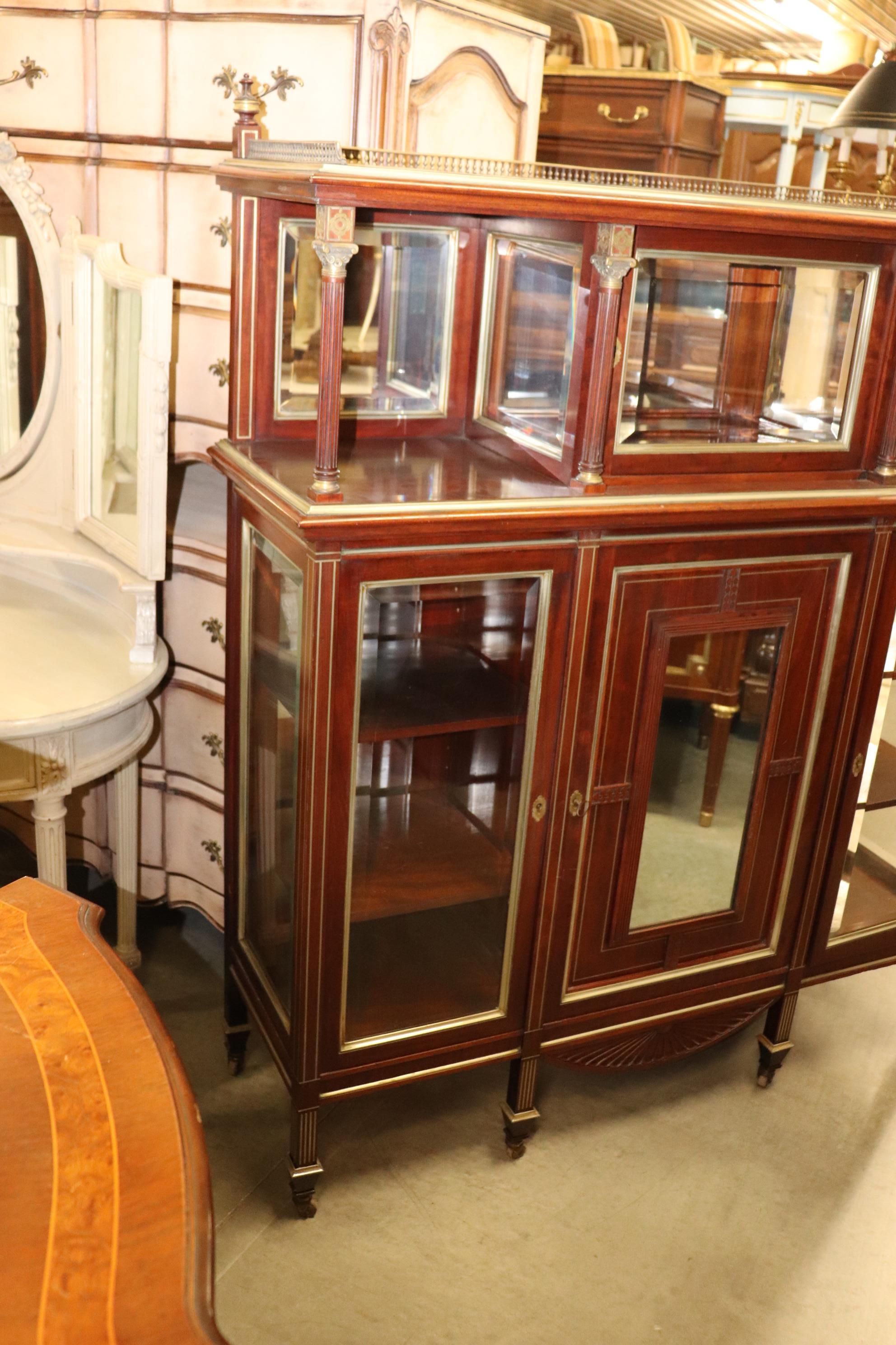 This fantastic Aesthetic Movement beveled mirror etagere at first looks French but it's actually a design that was adapted in the USA during the Victorian era. The piece is made of solid mahogany and features mirrored panels and beautiful cast