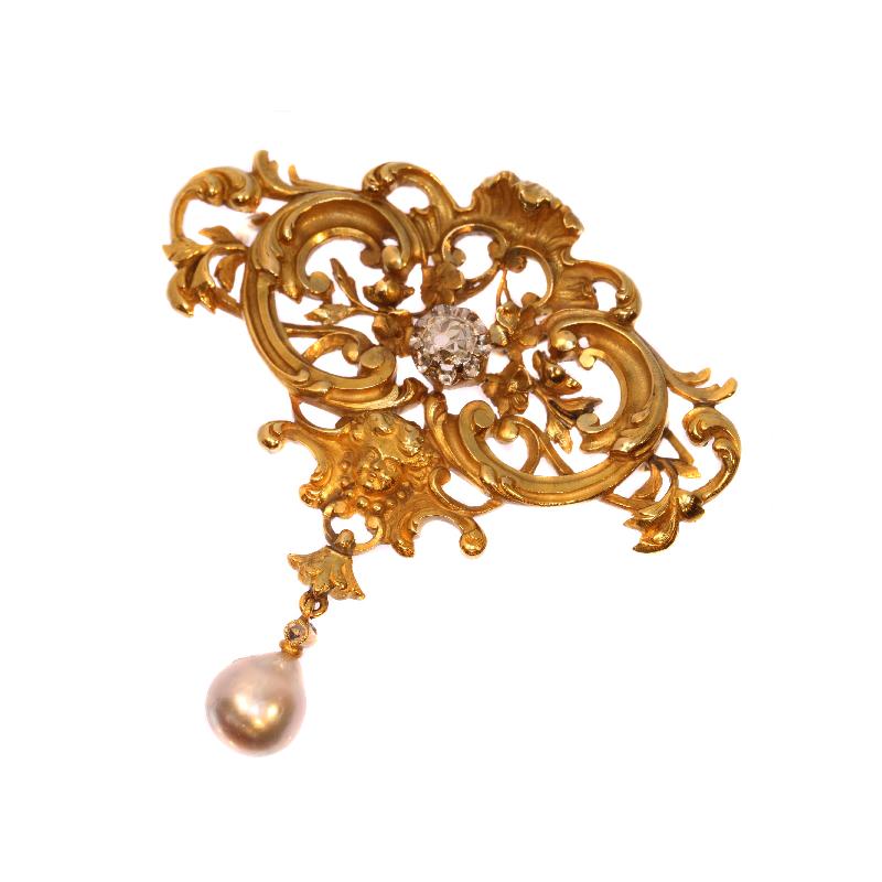 Let this 18K yellow gold French Victorian brooch flood your senses with its harmonious neo-Rococo openwork interplay of rocailles and flowers. As two blossoming branches sprout from the top shell, a wave of curly C-shapes and swirly S-shapes ripples