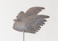 Cartel escultórico de metal con cara de Alekos Fassianos